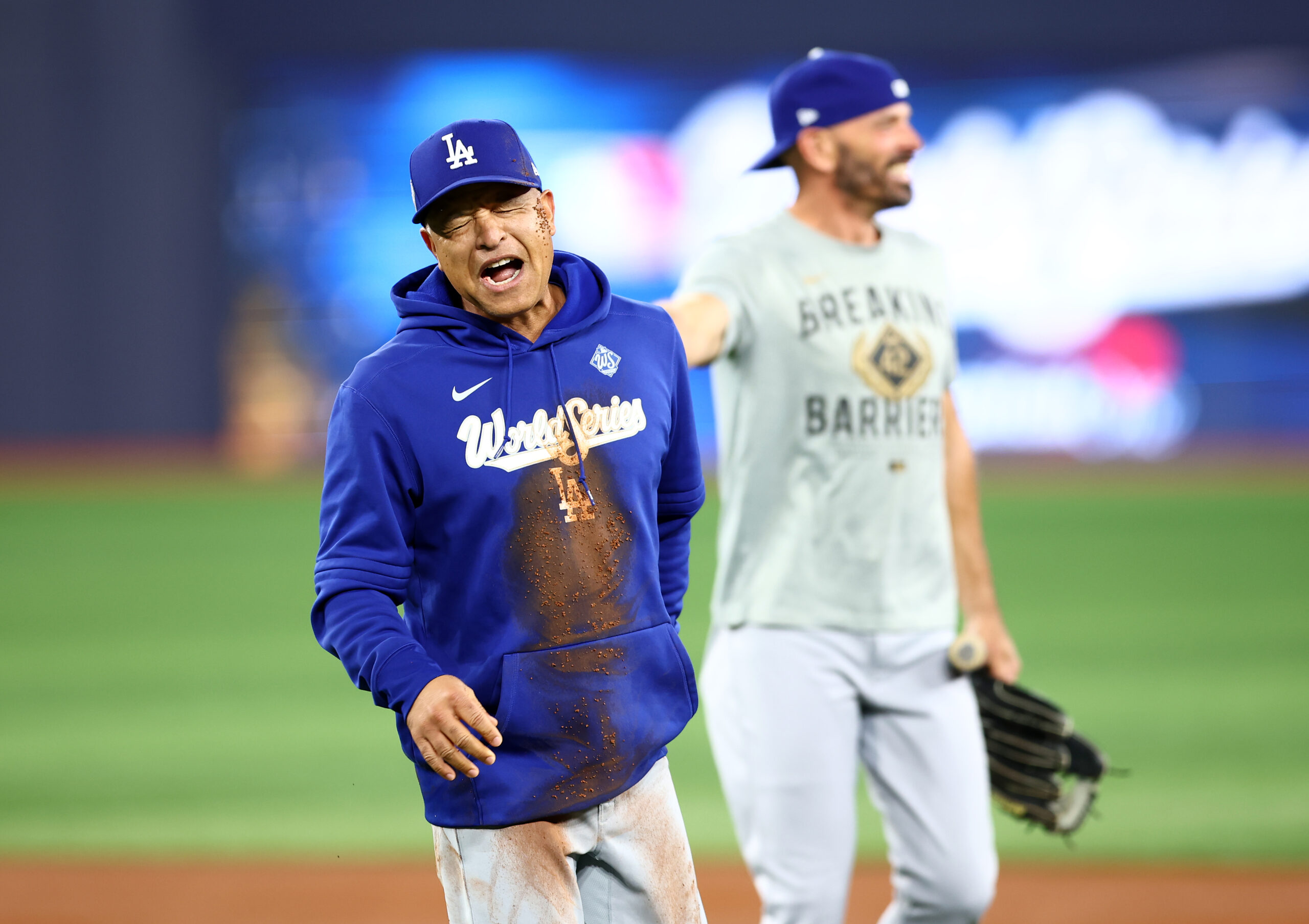 Dodgers manager Dave Roberts reacts after falling on the ground...
