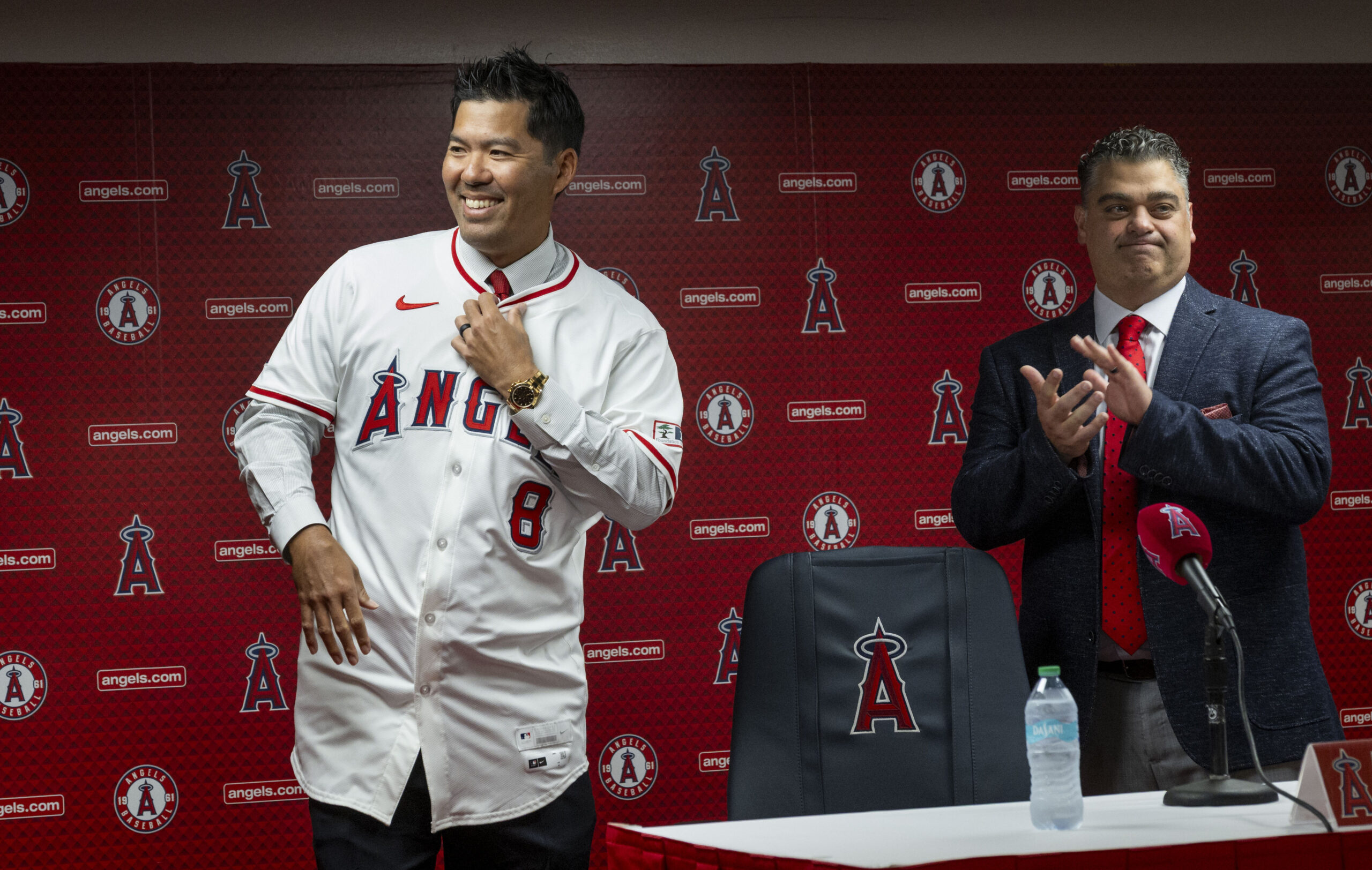 New Angels manager Kurt Suzuki, left, puts his jersey on...