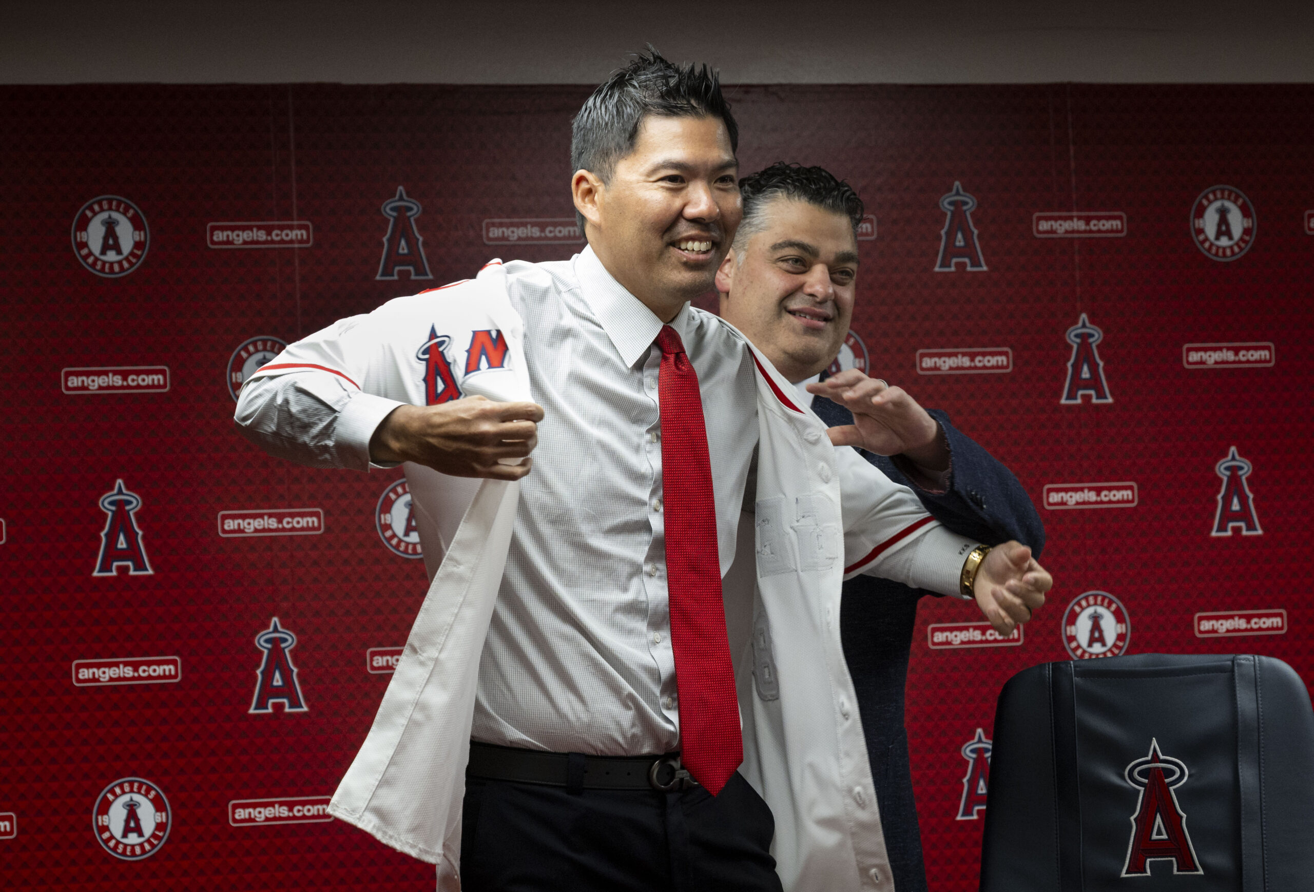 New Angels manager Kurt Suzuki, left, puts his jersey on...