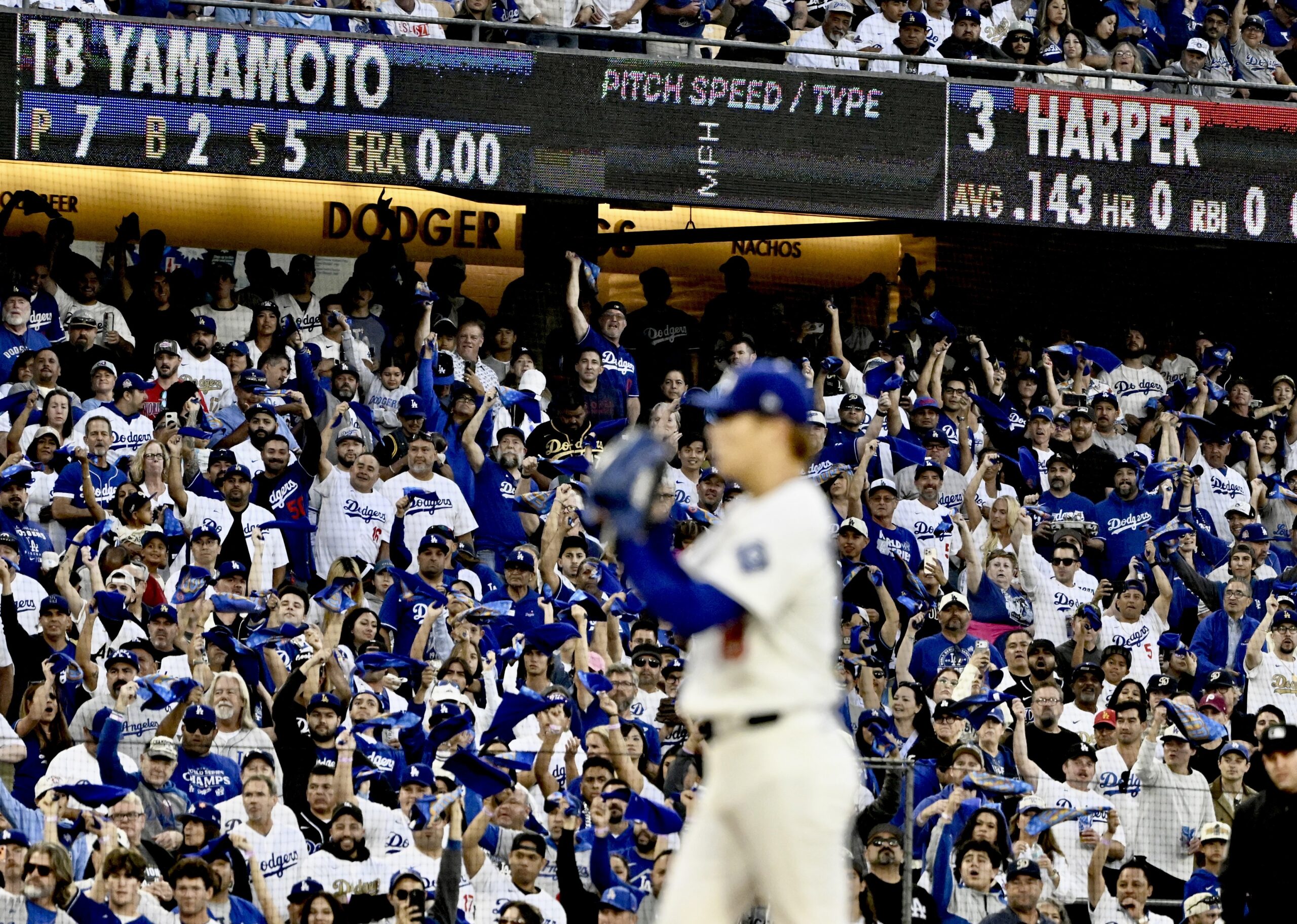 Dodgers starting pitcher Yoshinobu Yamamoto prepares to throw a pitch...