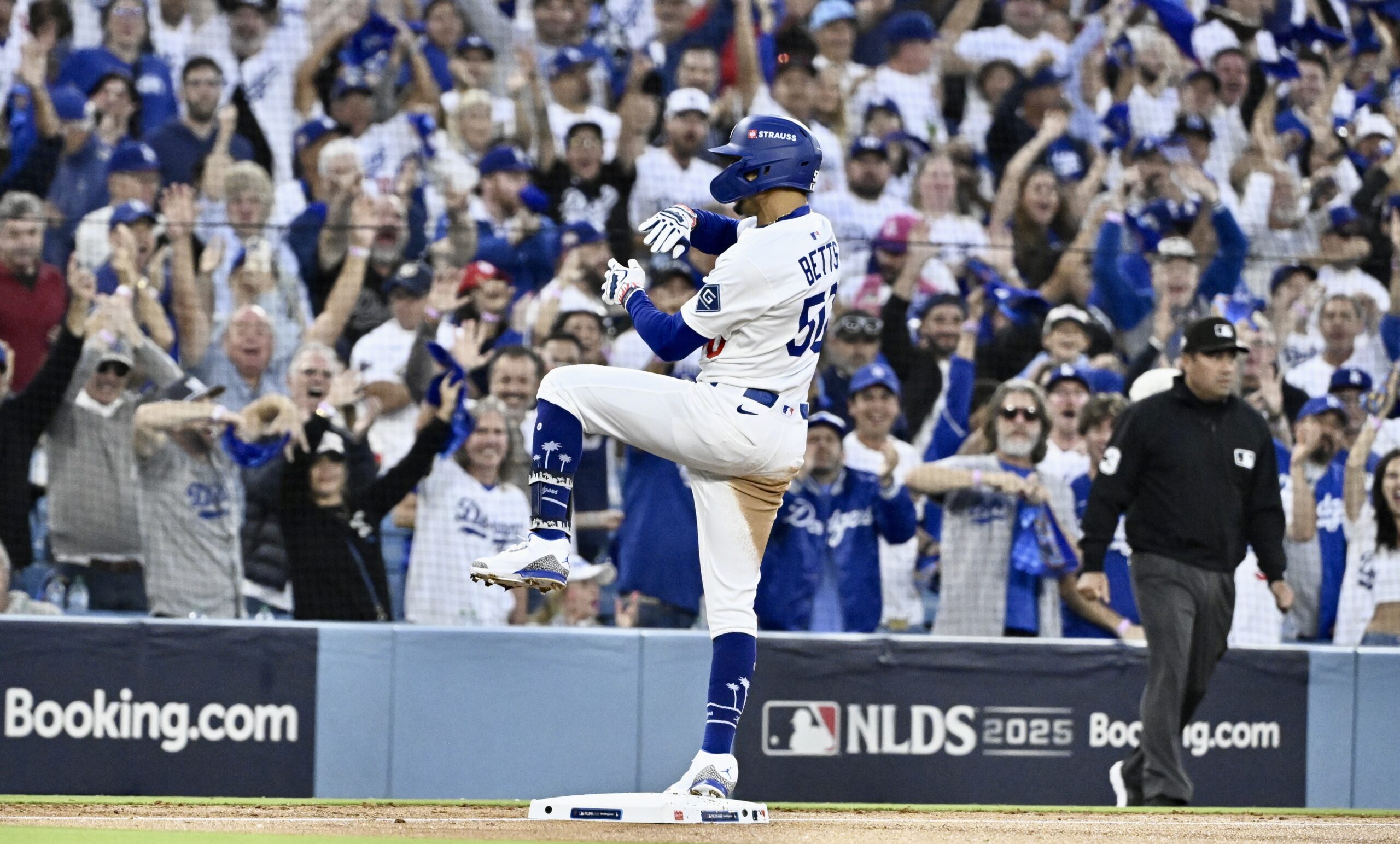 The Dodgers’ Mookie Betts celebrates at third base after hitting...