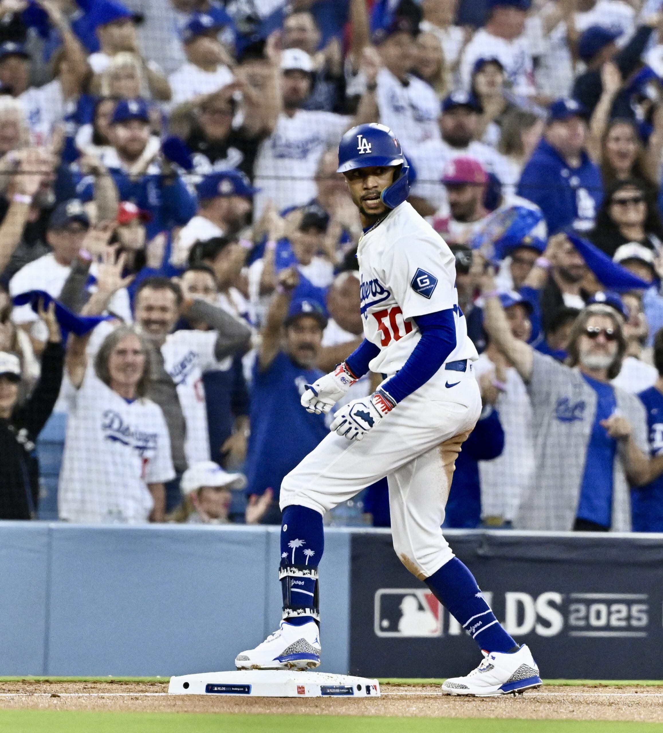 The Dodgers’ Mookie Betts celebrates at third base after hitting...