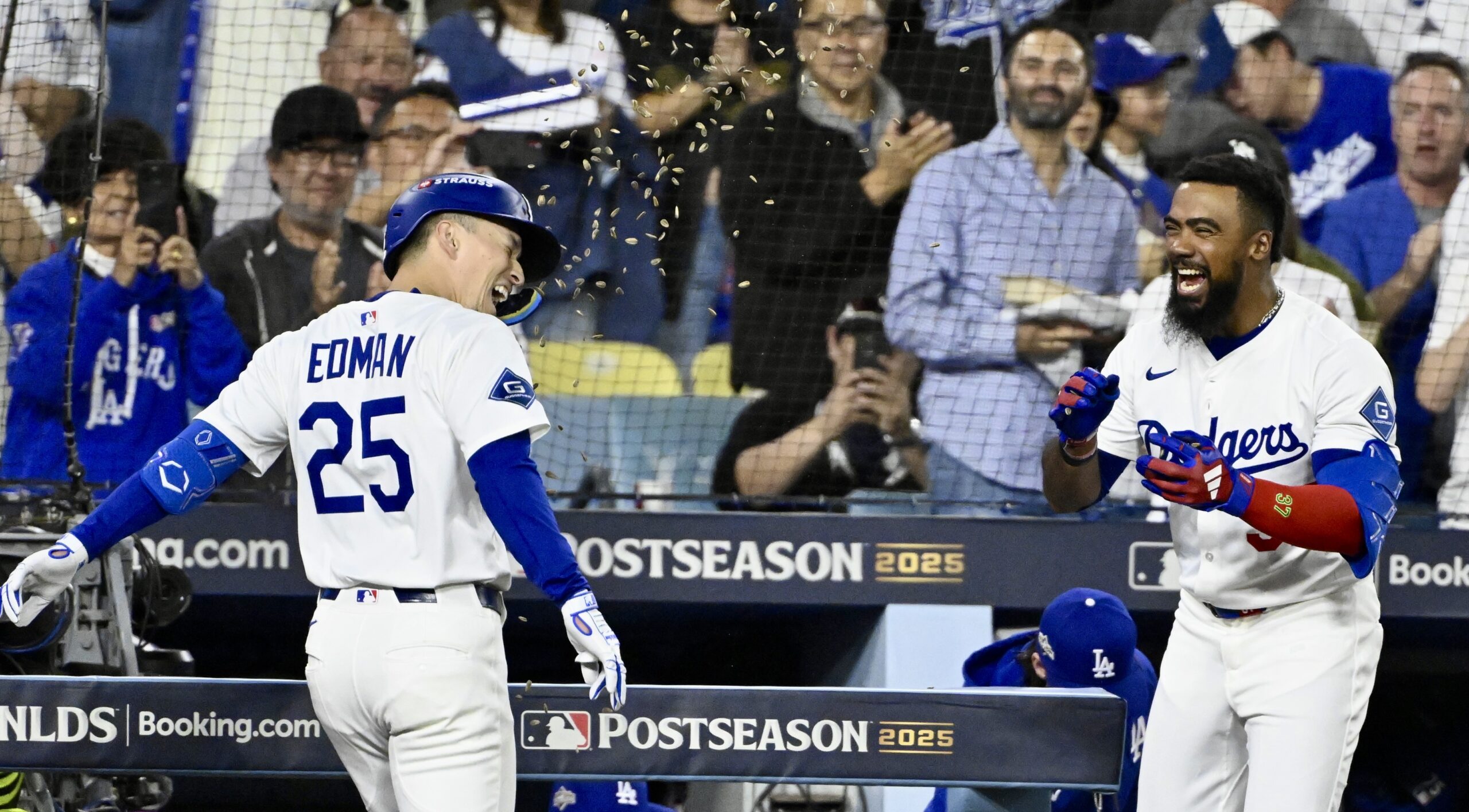 The Dodgers’ Tommy Edman, left, is showered with sunflower seeds...