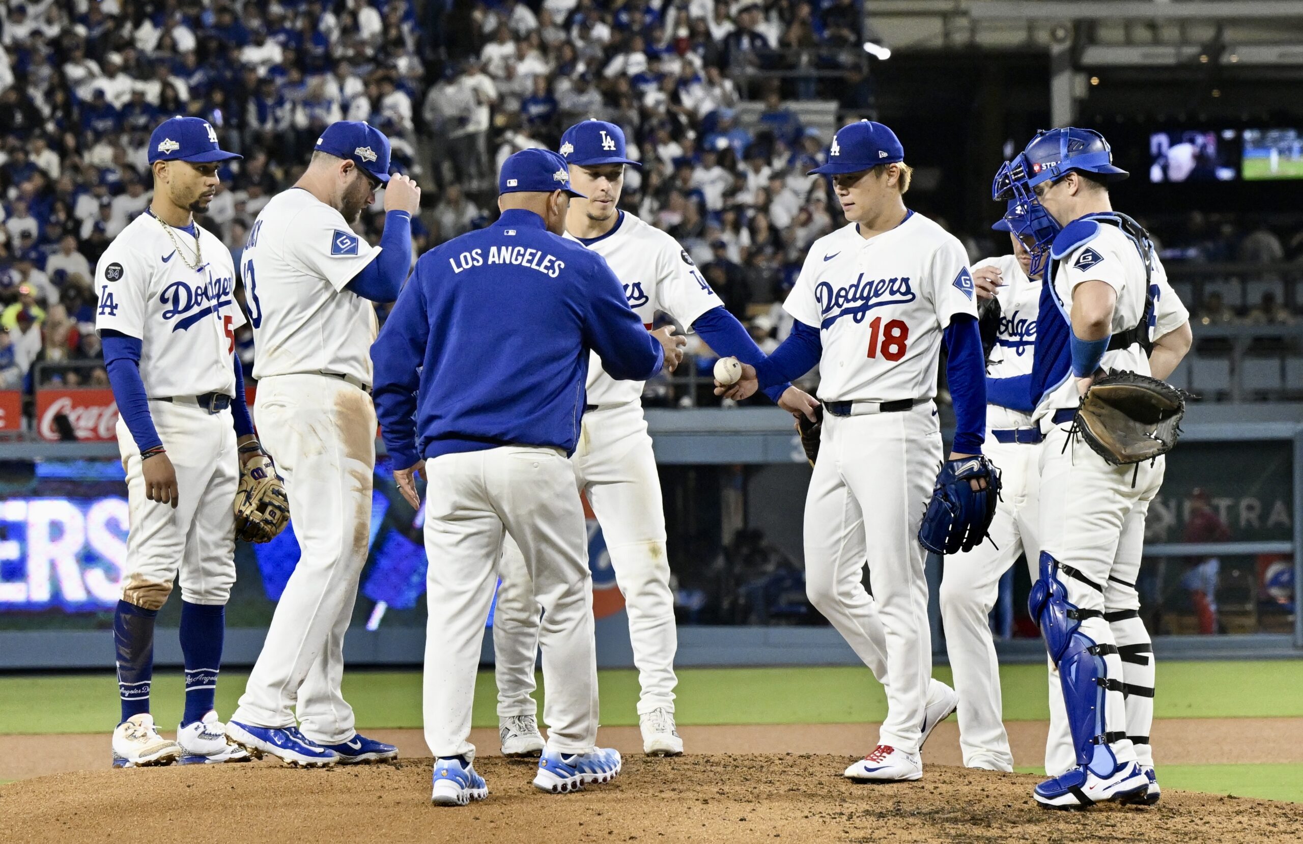 Dodgers manager Dave Roberts takes the ball from starting pitcher...