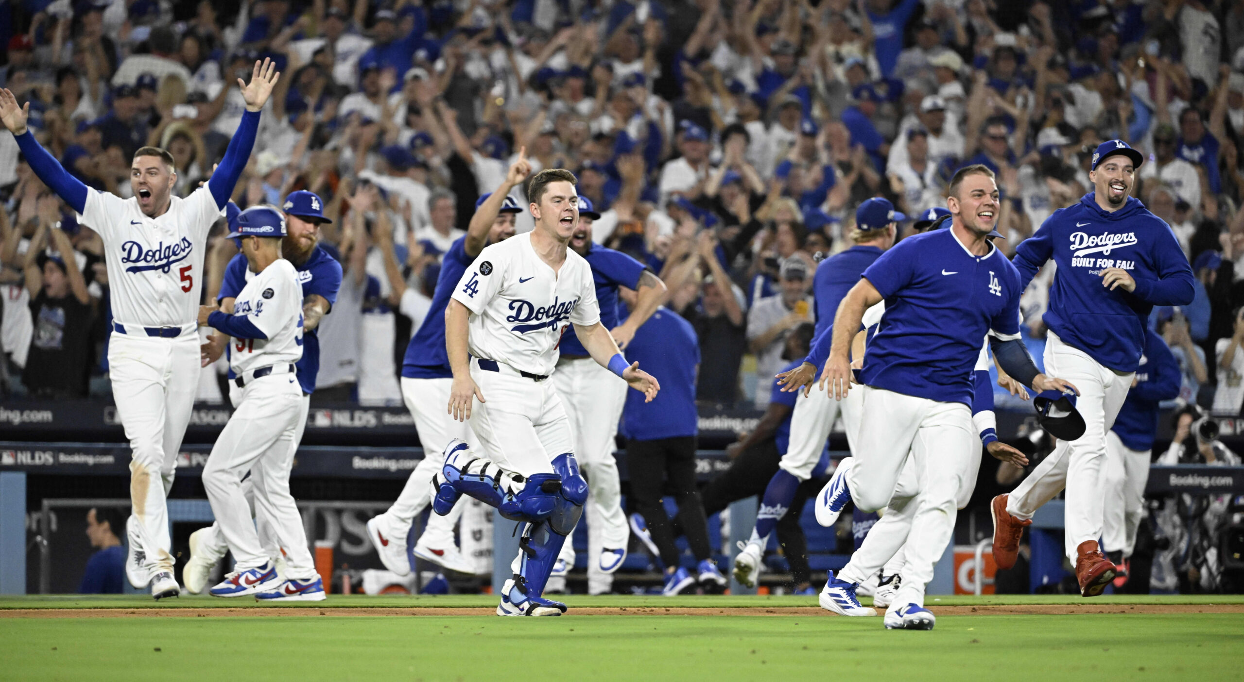 The Dodgers rush the field to celebrate their 2-1, 11-inning...