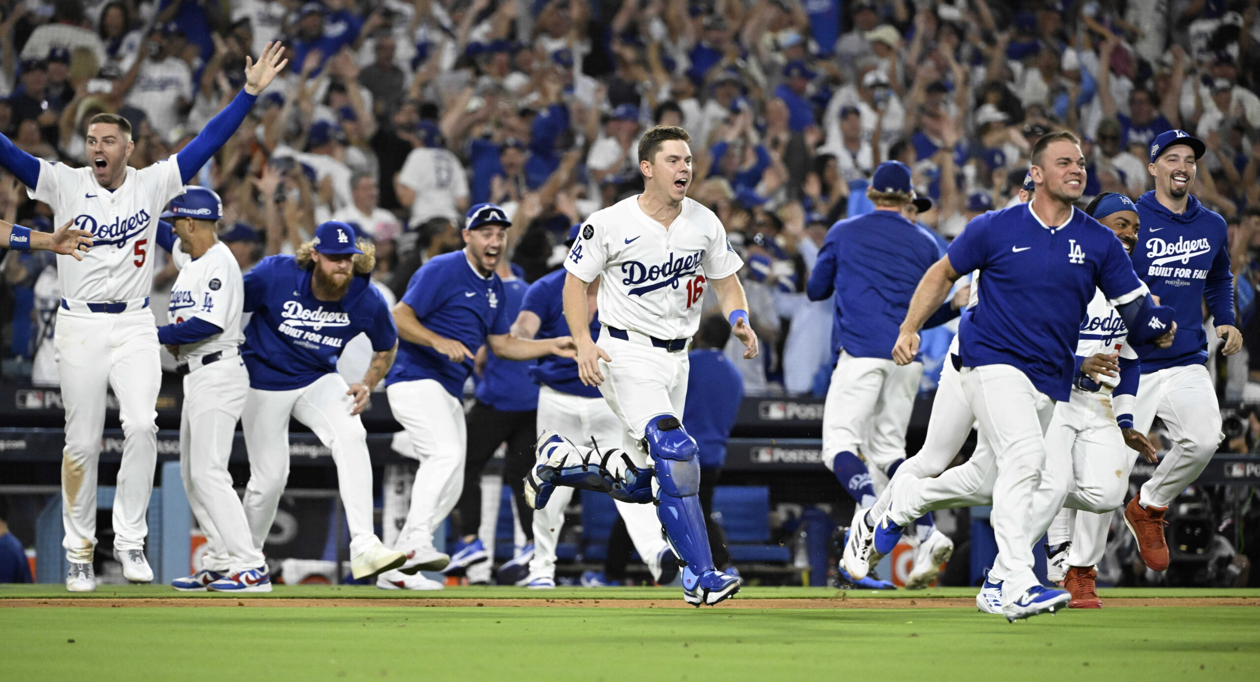 The Dodgers rush the field to celebrate their 2-1, 11-inning...