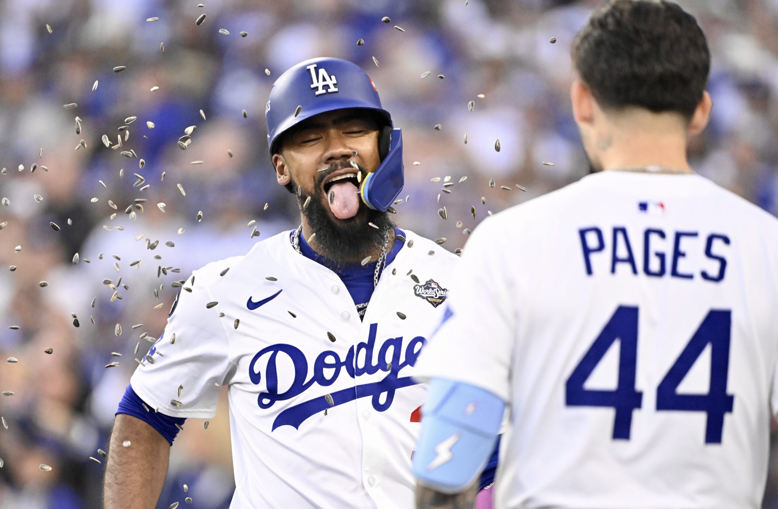 The Dodgers’ Teoscar Hernández, left, is showered with sunflower seeds...
