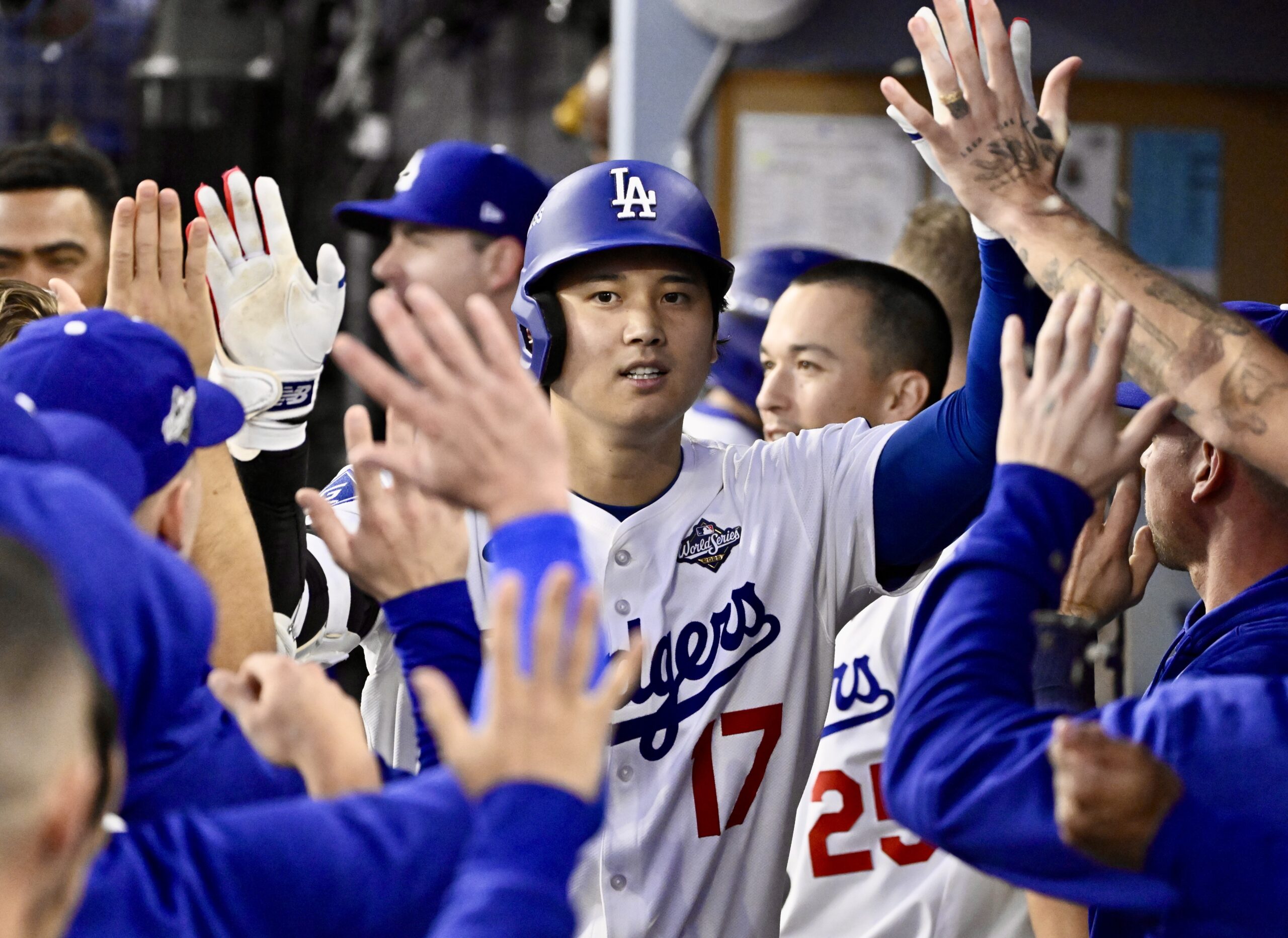 Dodgers star Shohei Ohtani celebrates with teammates in the dugout...