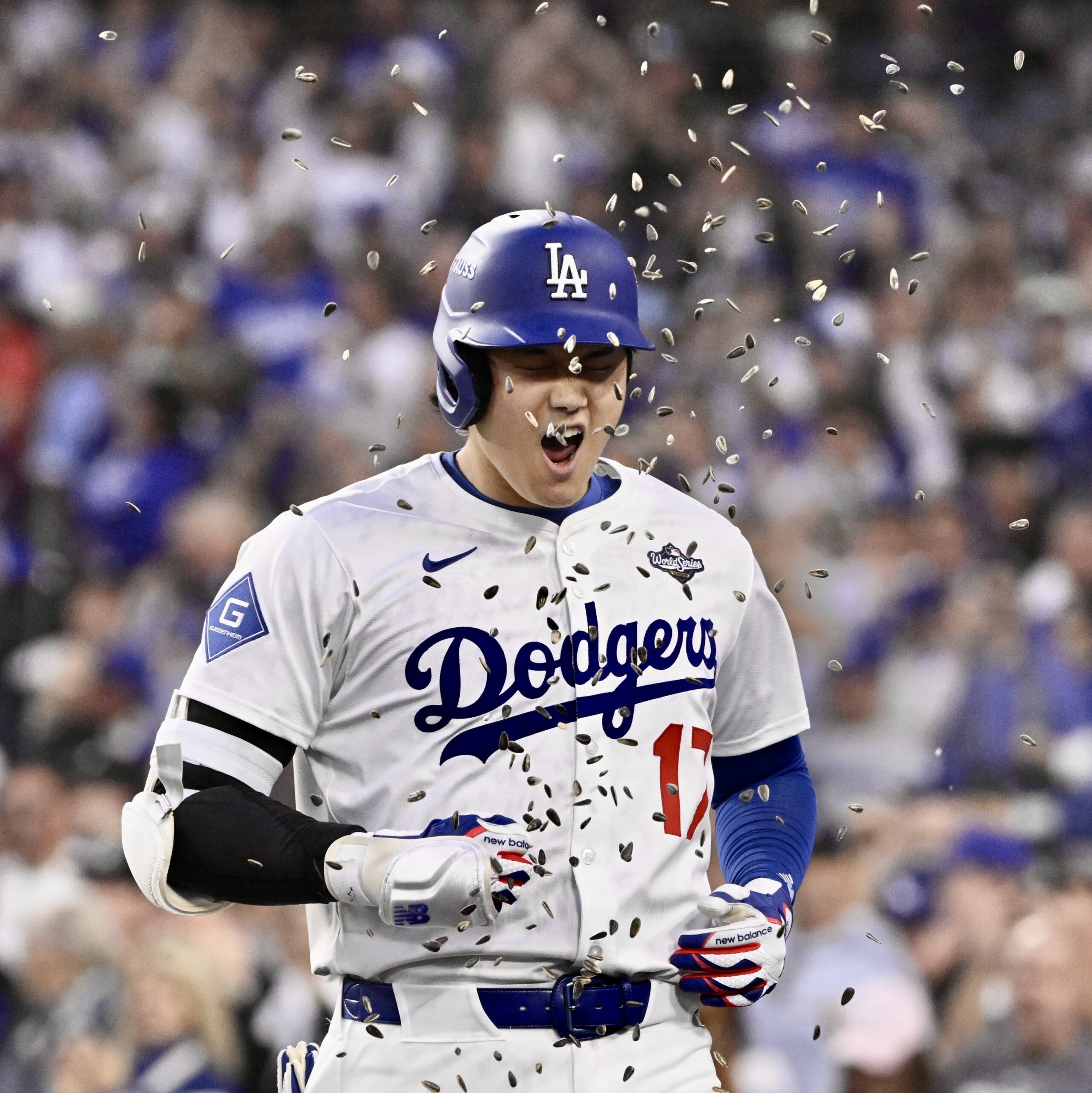 Dodgers star Shohei Ohtani is showered with sunflower seeds as...