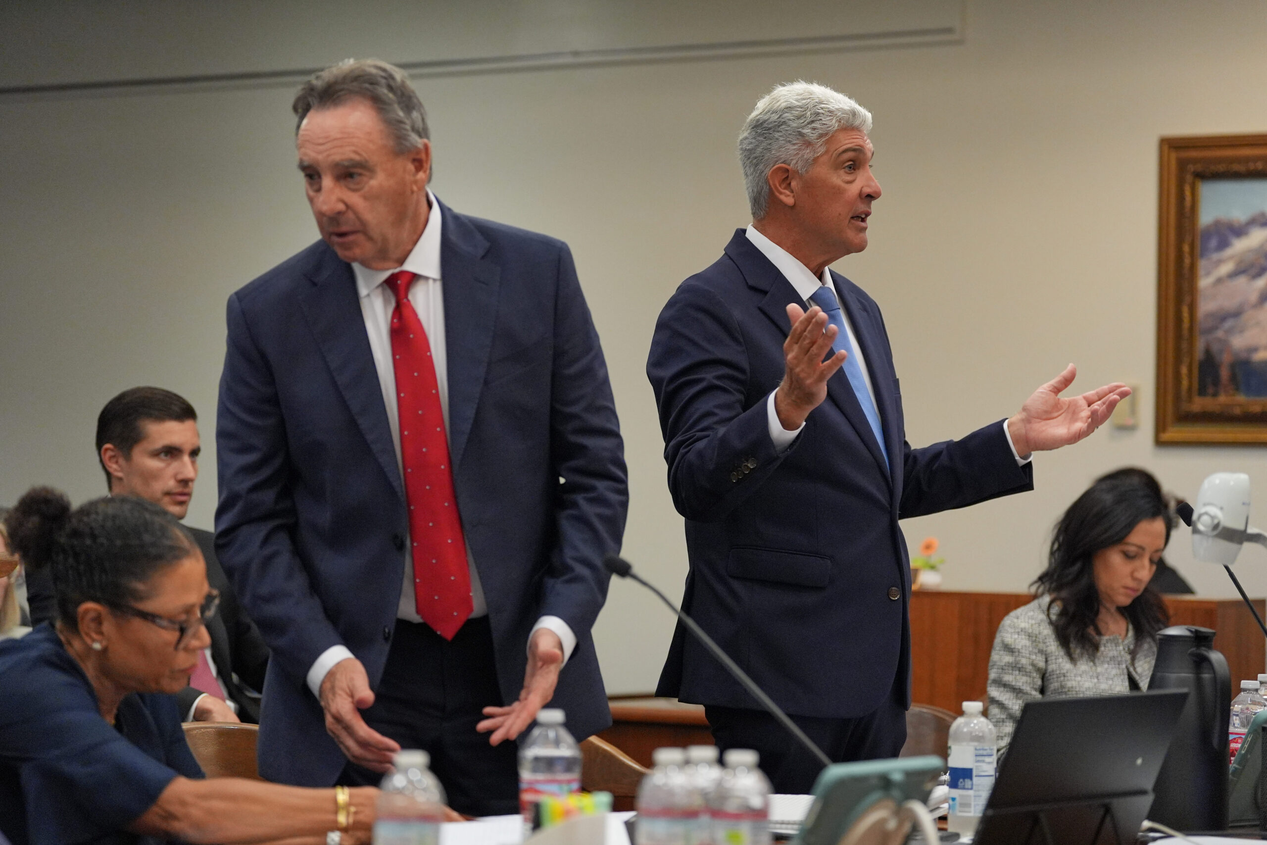 Attorney Todd Theodora, right, gestures as he speaks alongside attorneys...