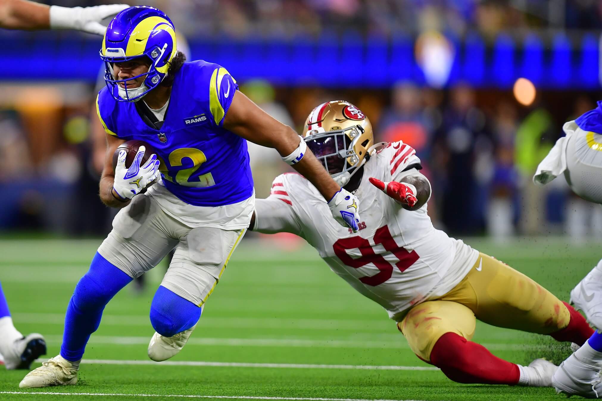 Oct 2, 2025; Inglewood, California, USA; Los Angeles Rams wide receiver Puka Nacua (12) makes a catch past San Francisco 49ers defensive tackle Sam Okuayinonu (91) during the second half at SoFi Stadium. Mandatory Credit: Gary A. Vasquez-Imagn Images