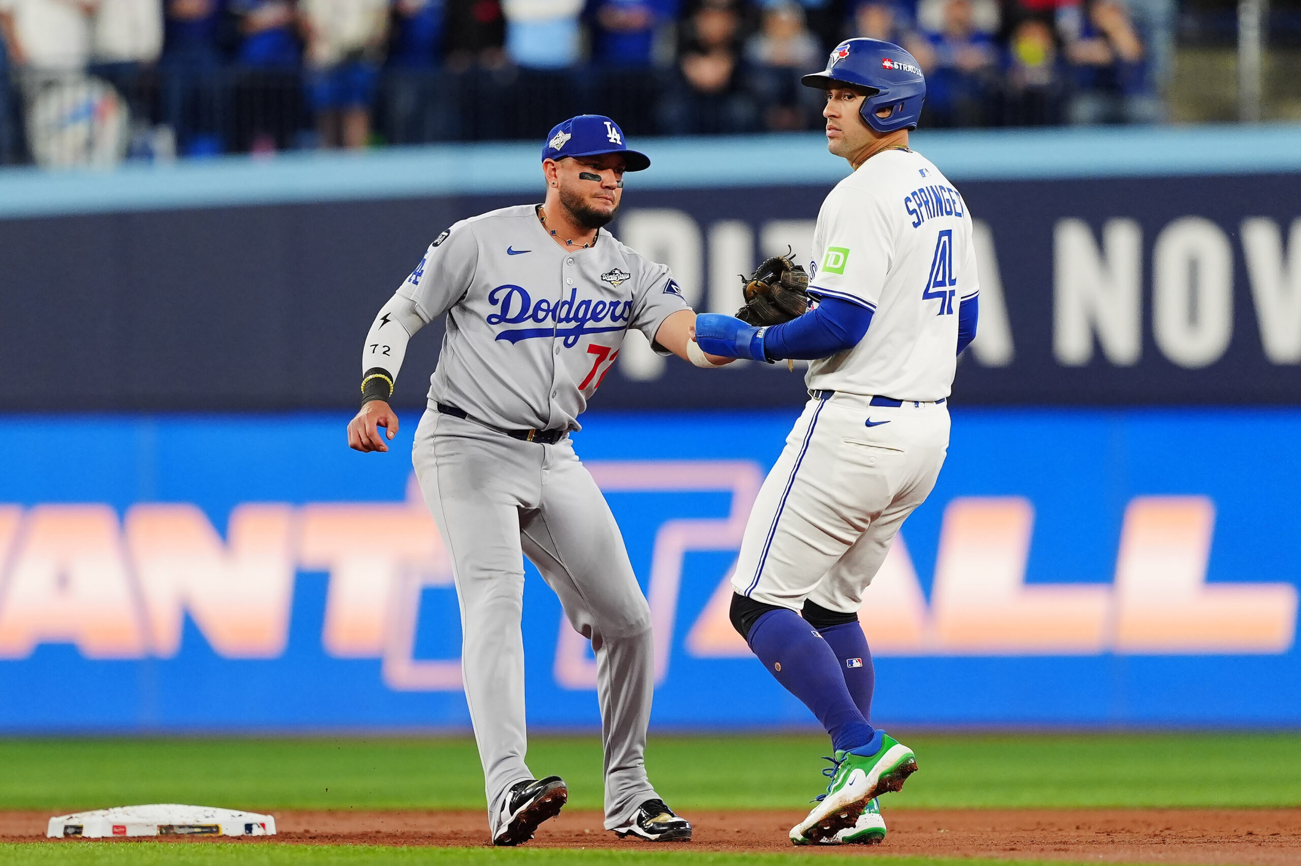 Toronto Blue Jays designated hitter George Springer, right, is tagged...