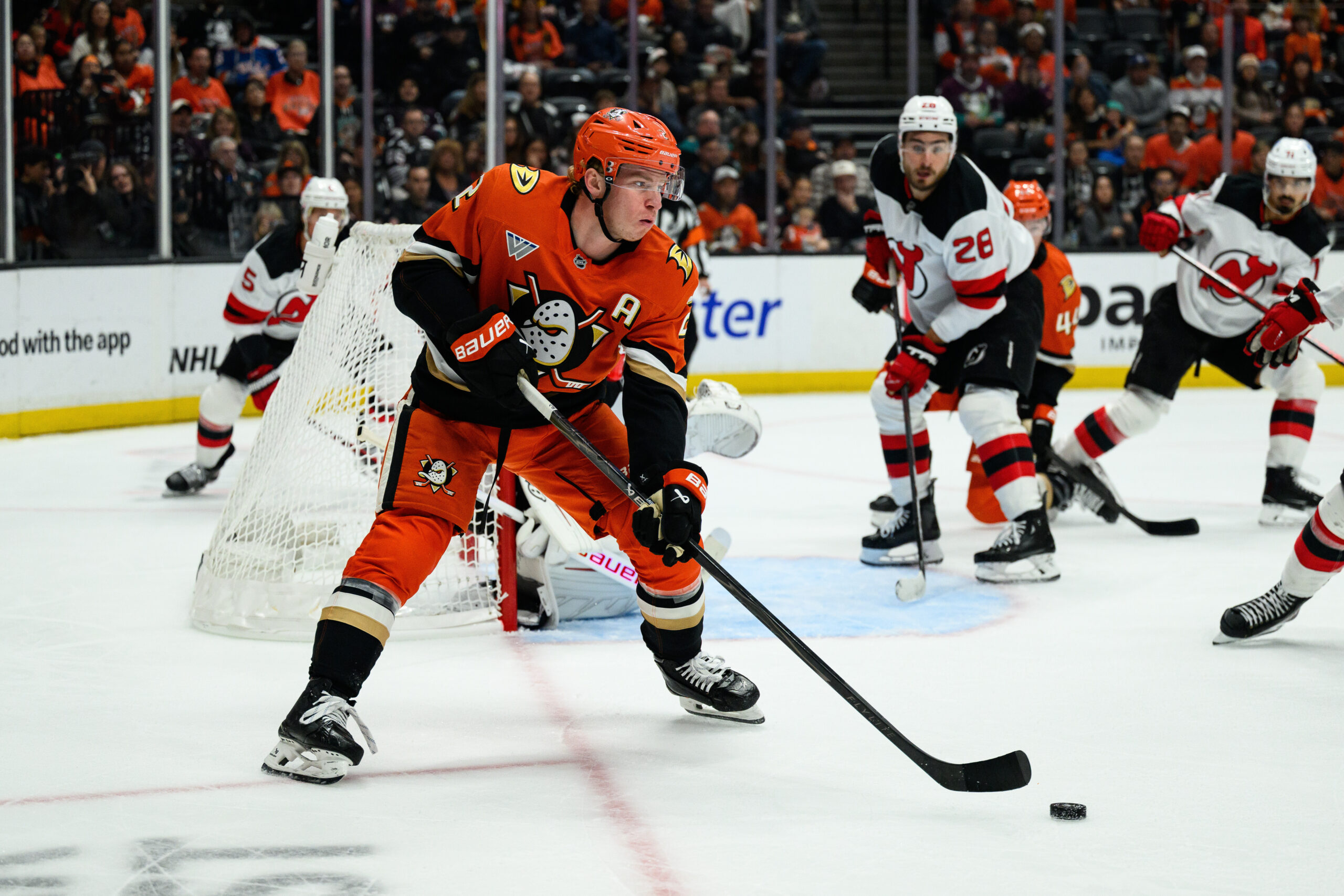 Ducks defenseman Jackson Lacombe, left, controls the puck during the...