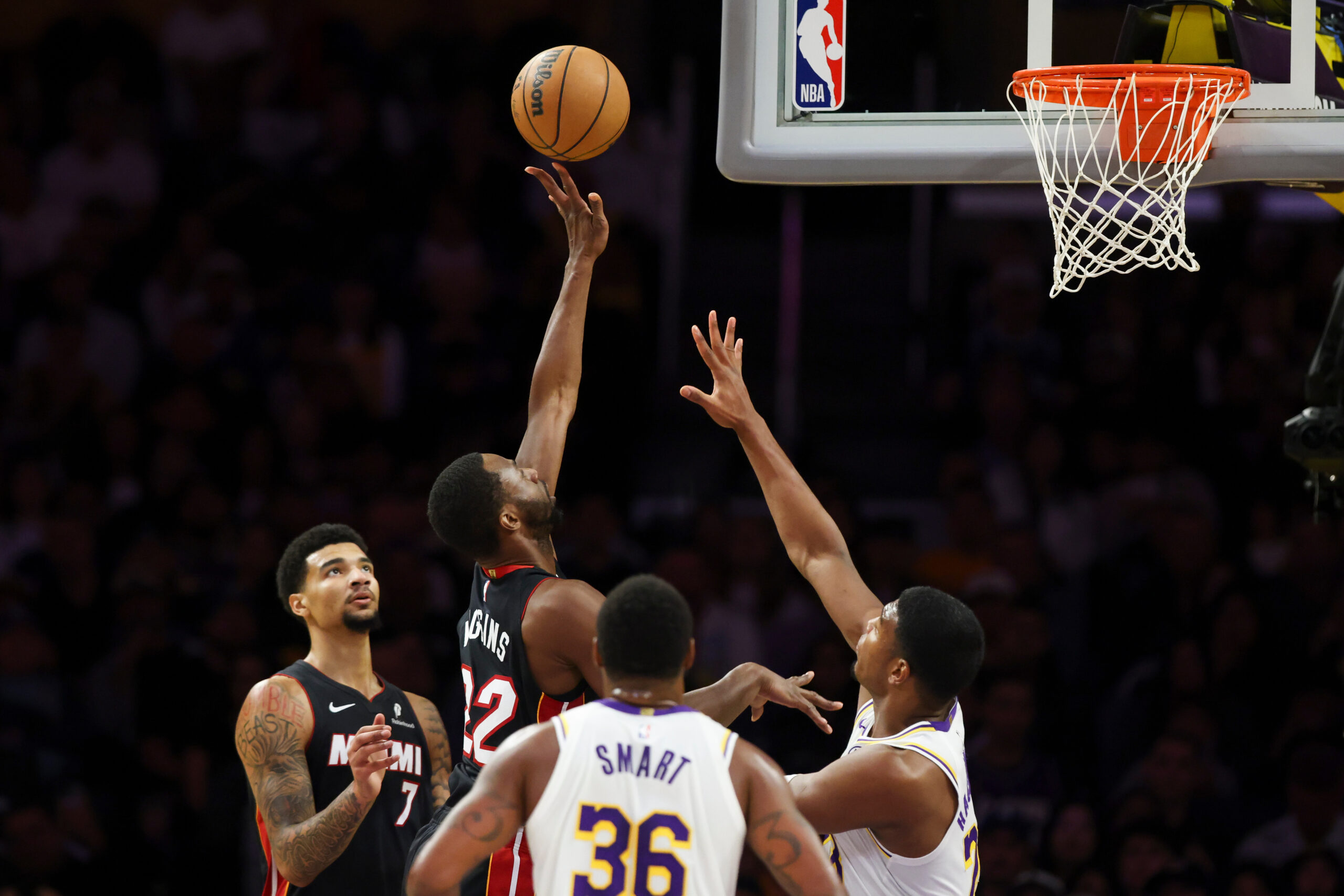 Miami Heat forward Andrew Wiggins, center, shoots as center Kel’el...