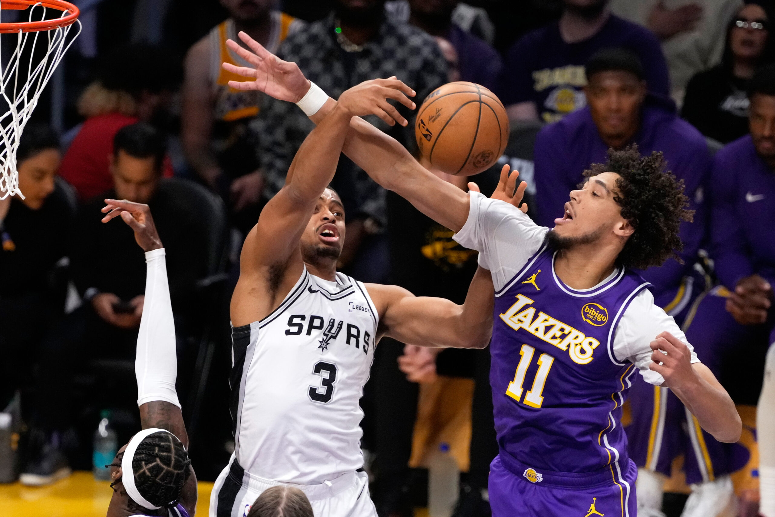 San Antonio Spurs forward Keldon Johnson, left, and Lakers center...