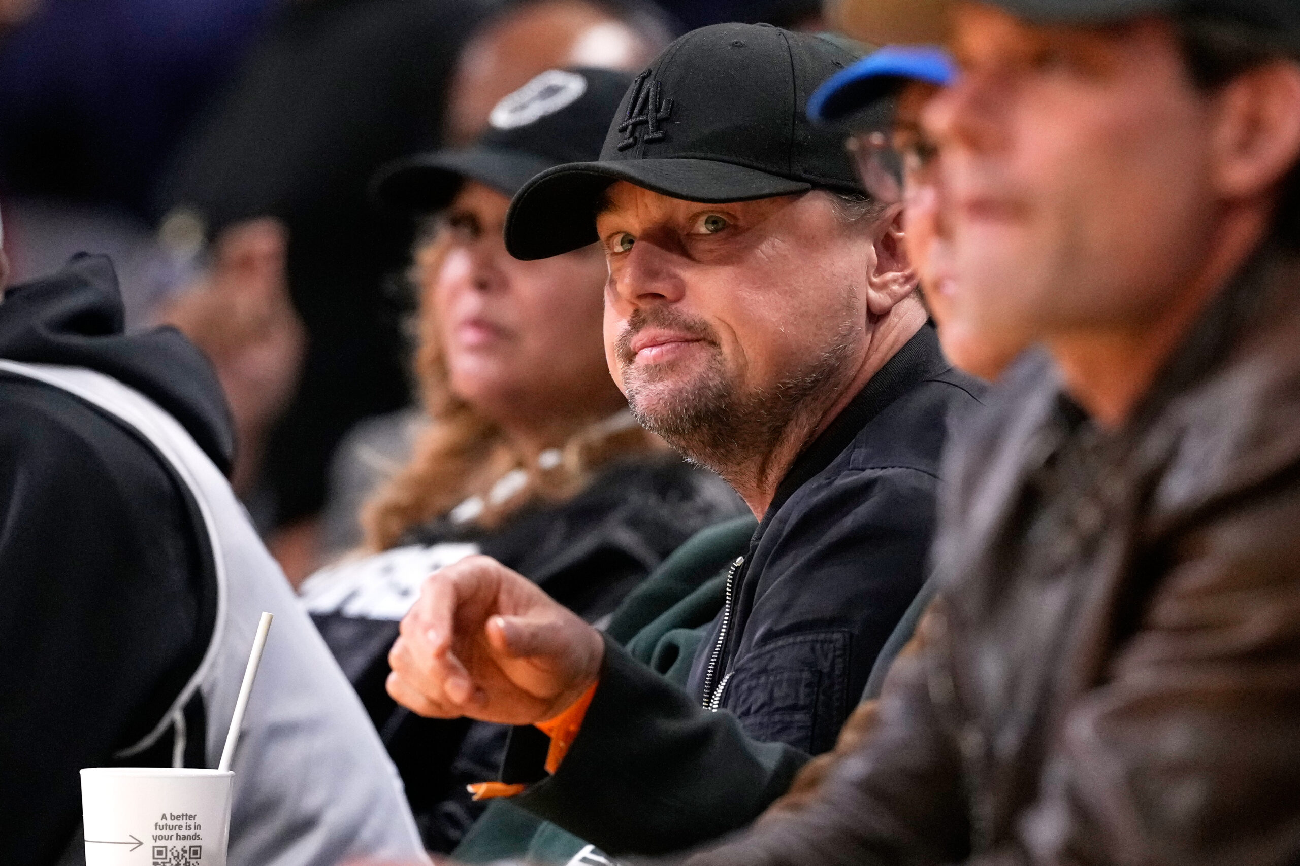Actor Leonardo DiCaprio watches from a courtside seat during the...