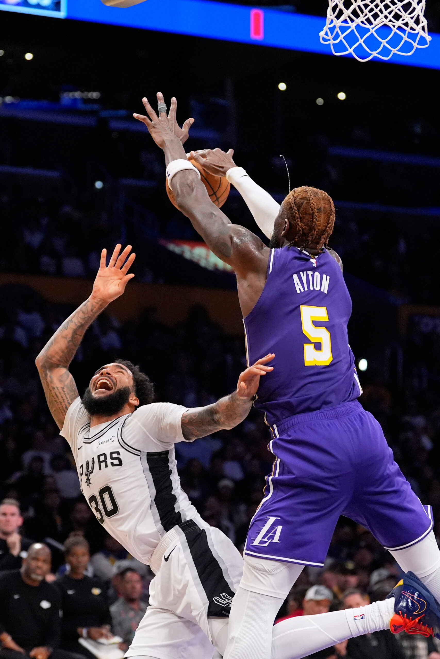 San Antonio Spurs forward Julian Champagnie, left, shoots as Lakers...