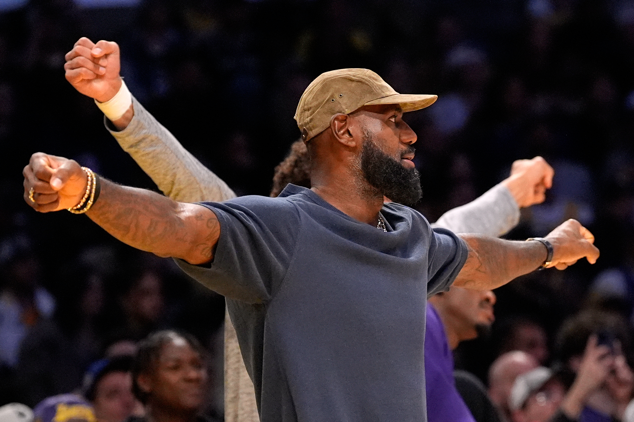 Injured Lakers star LeBron James gestures from the bench during...