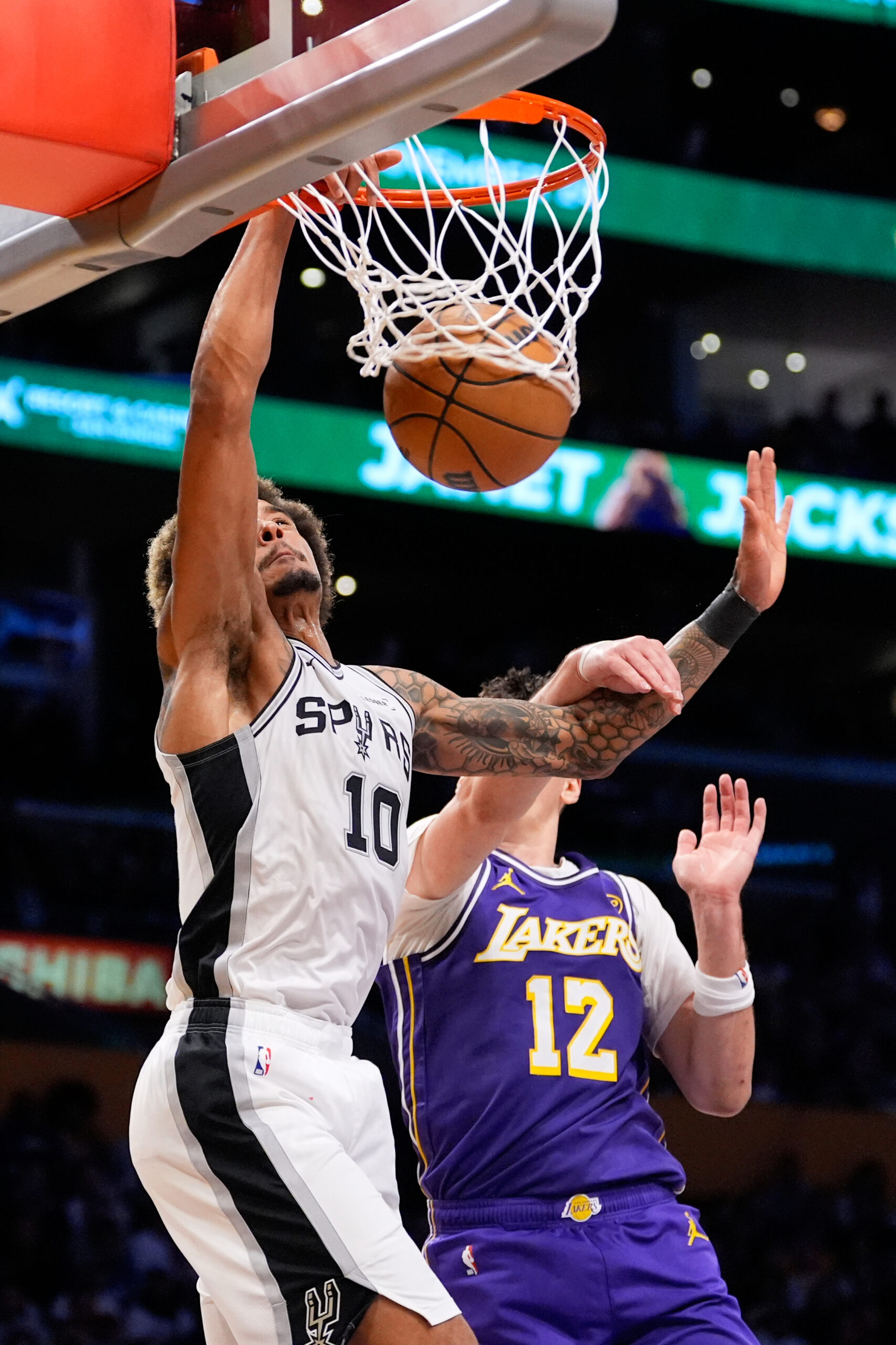 San Antonio Spurs forward Jeremy Sochan, left, dunks as Lakers...