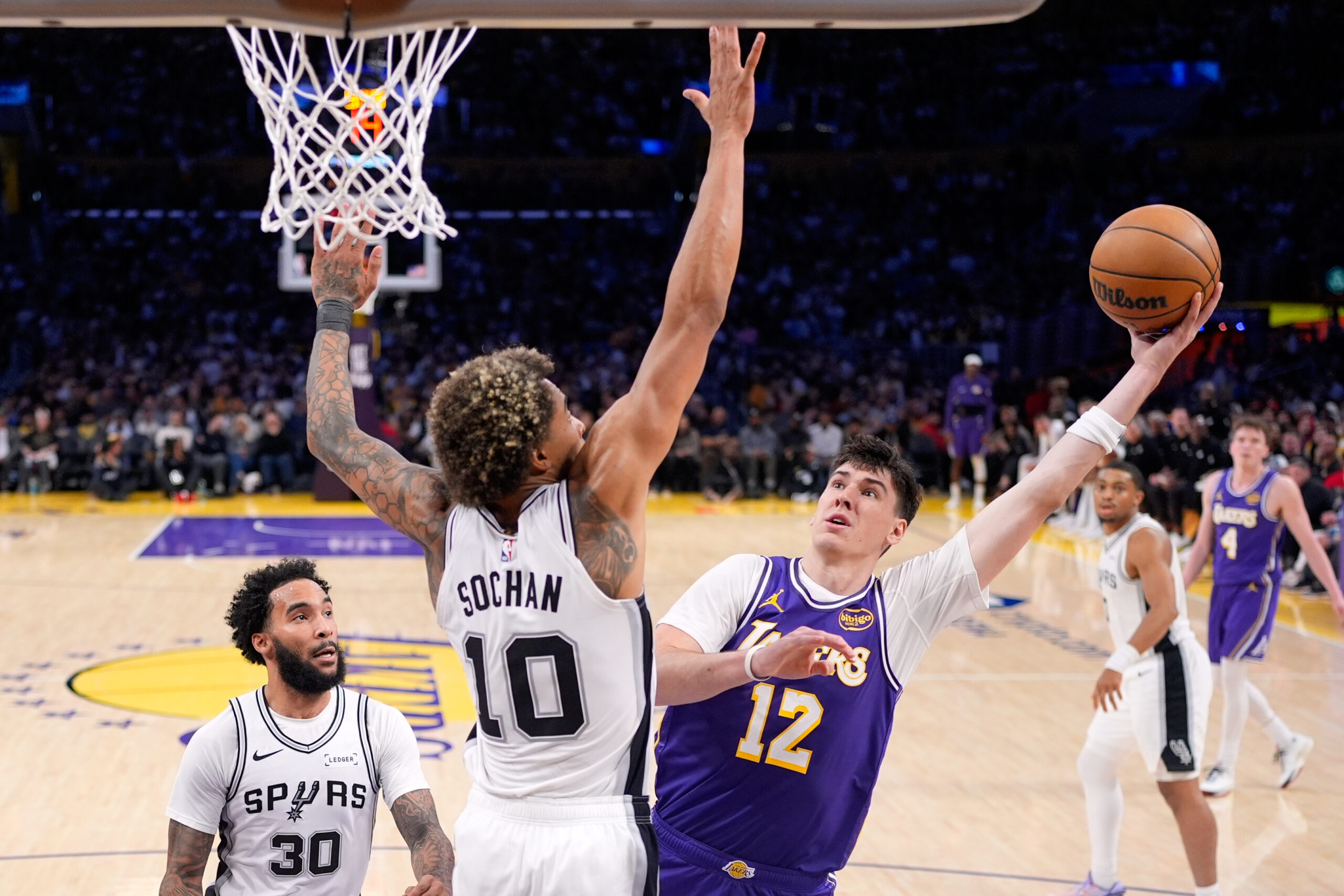 Lakers forward Jake LaRavia, right, shoots as San Antonio Spurs...