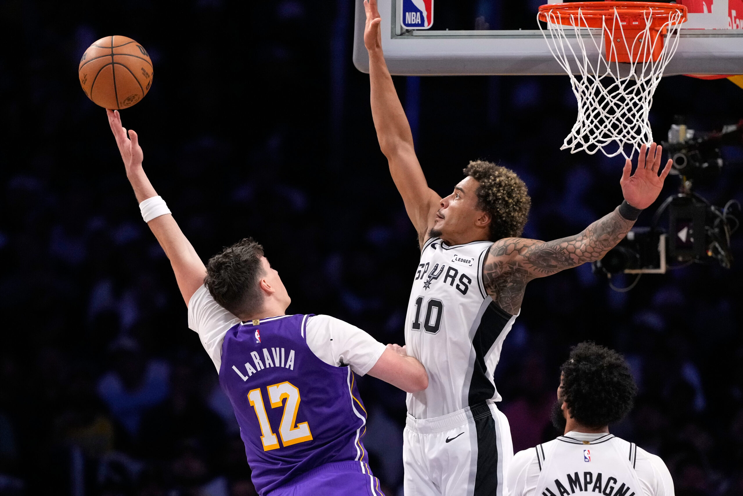 Lakers forward Jake LaRavia, left, shoots as San Antonio Spurs...