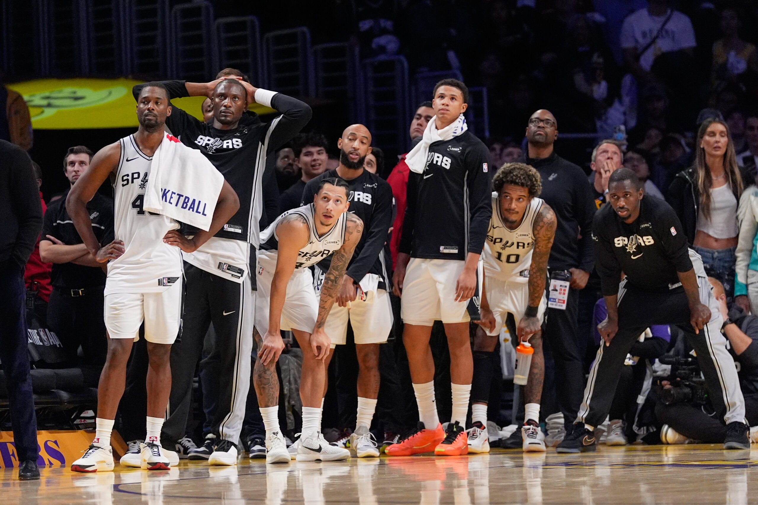 Members of the San Antonio Spurs watch from the bench...