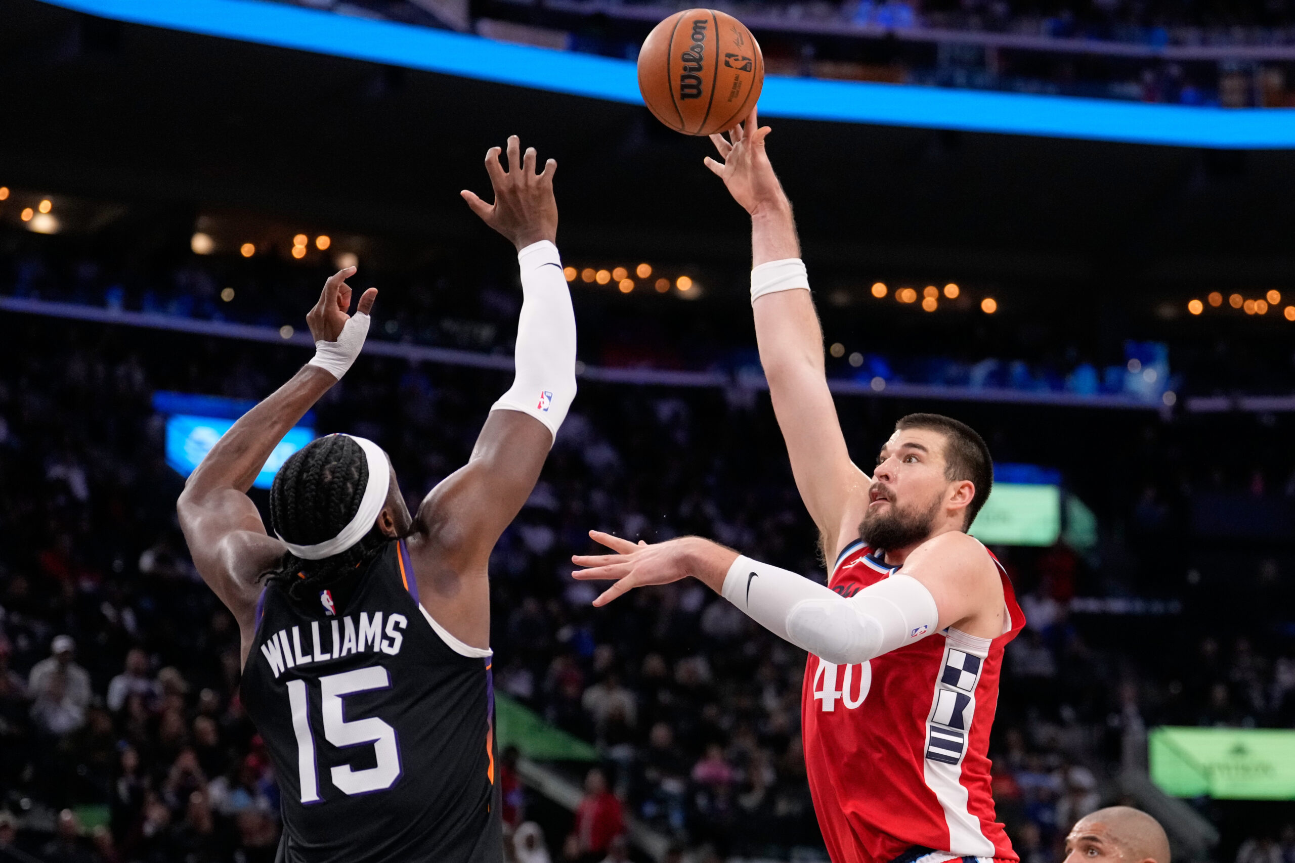 Clippers center Ivica Zubac, right, shoots as Phoenix Suns center...