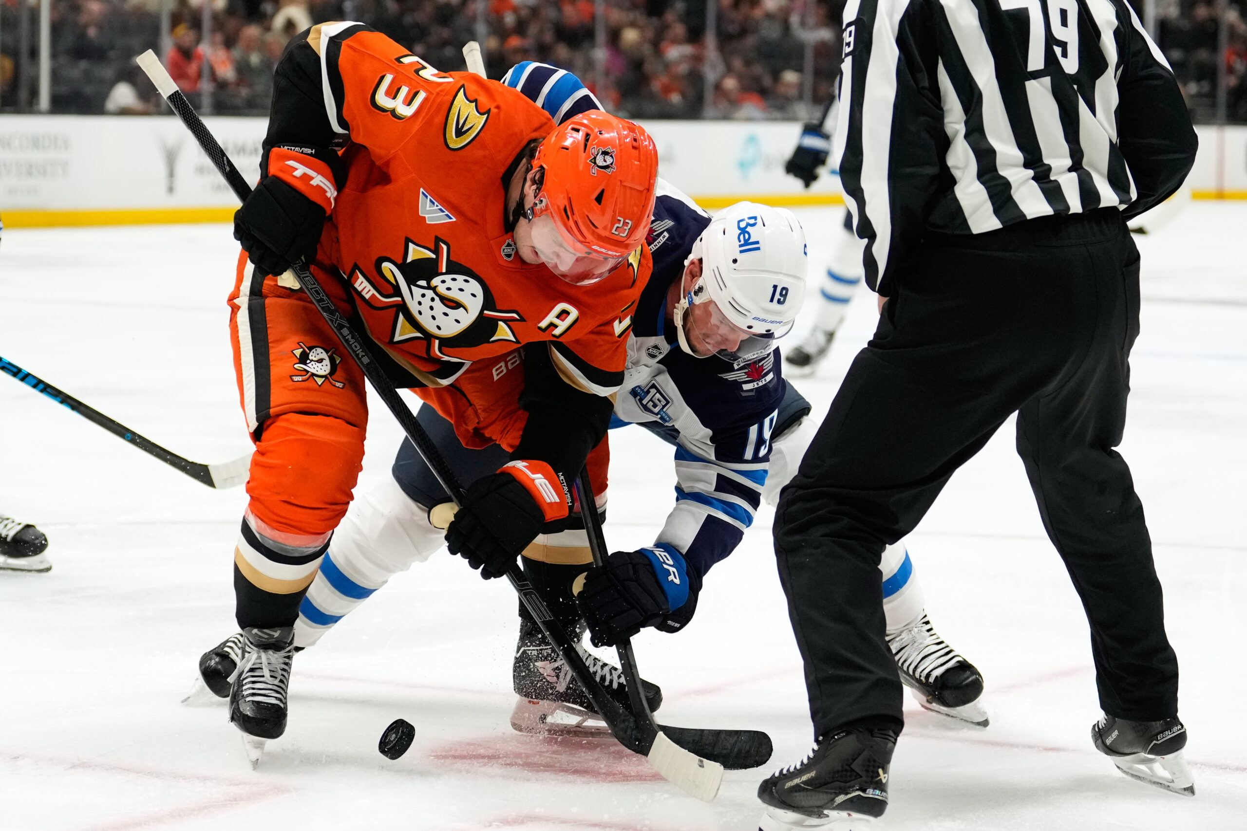 Ducks center Mason McTavish, left, and Winnipeg Jets center Jonathan...