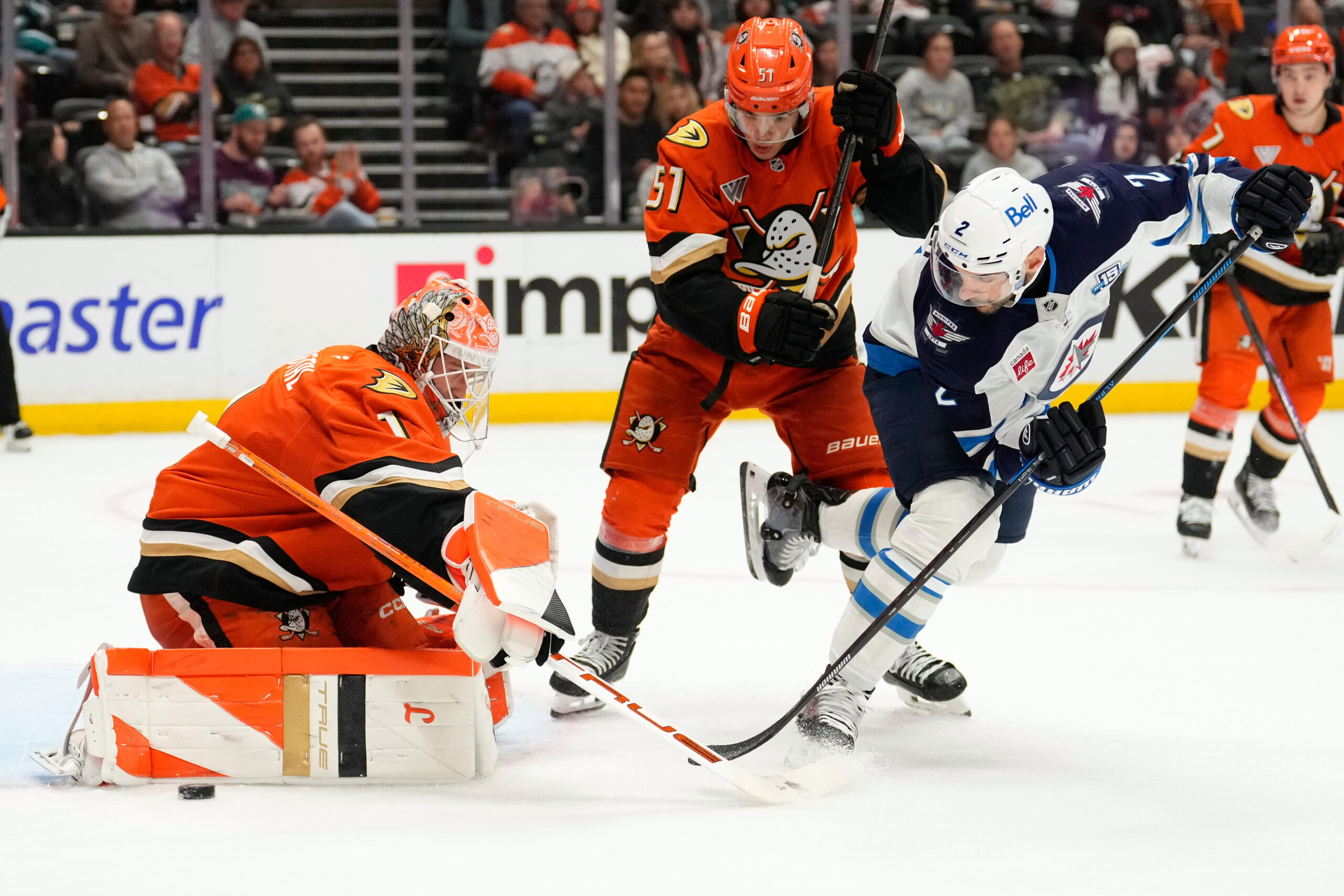 Winnipeg Jets defenseman Dylan DeMelo, right, tries to get a...
