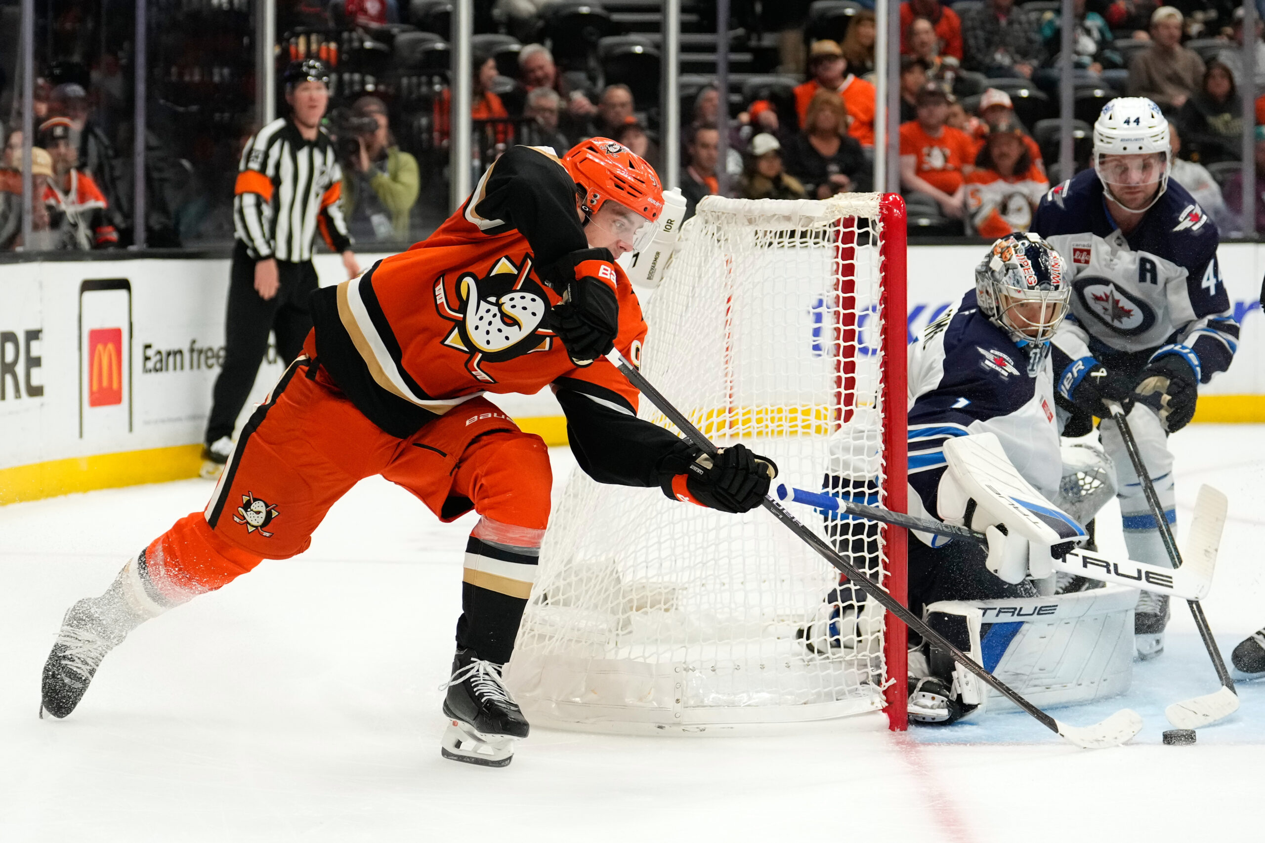 Ducks center Leo Carlsson, left, tries to get a shot...