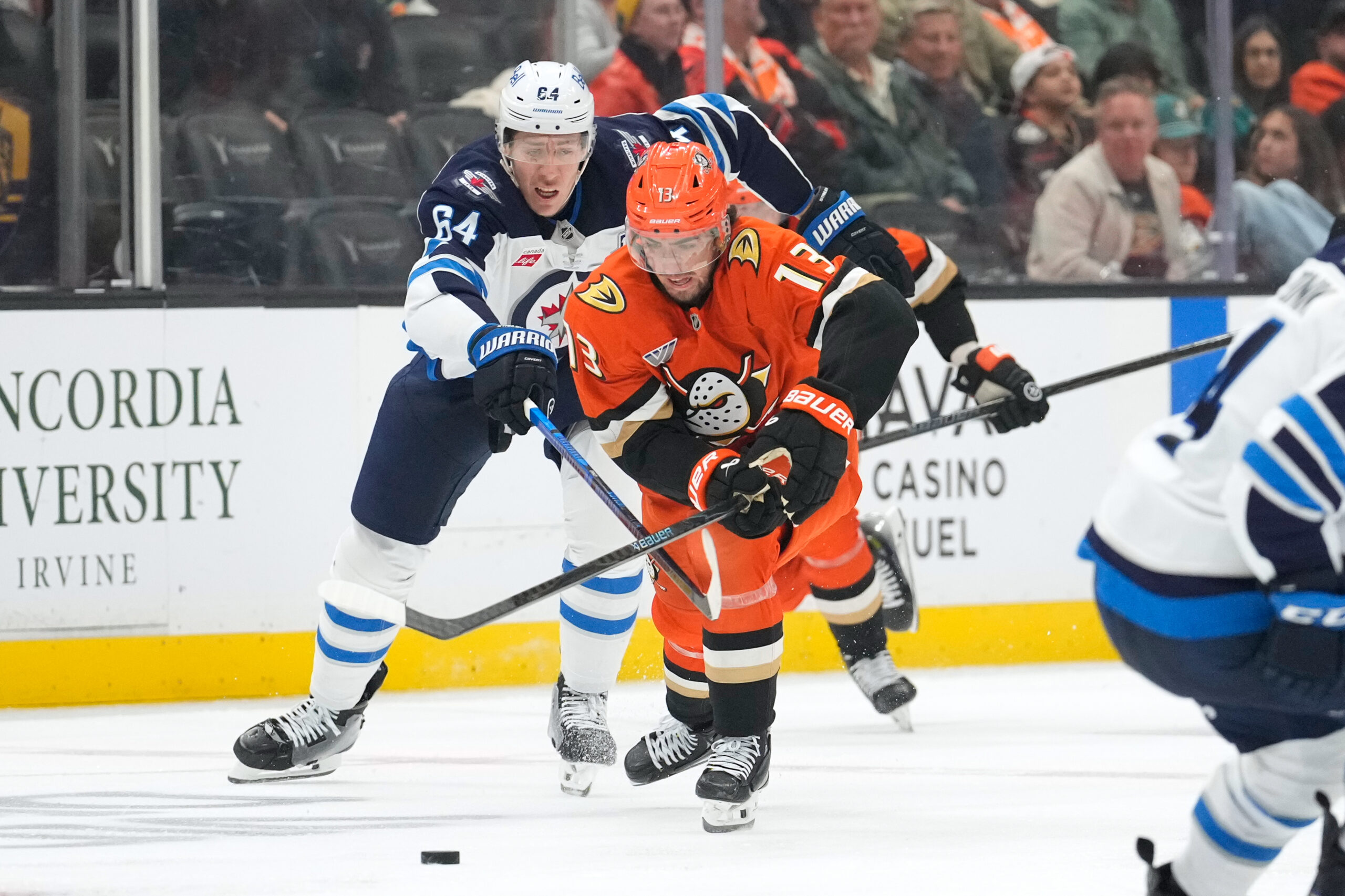 Winnipeg Jets defenseman Logan Stanley, left, reaches in on Ducks...