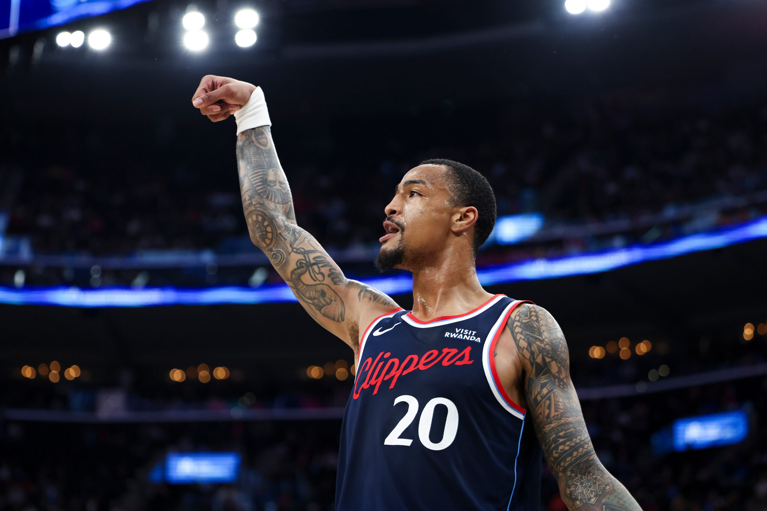 Clippers forward John Collins follows through on a 3-point shot...