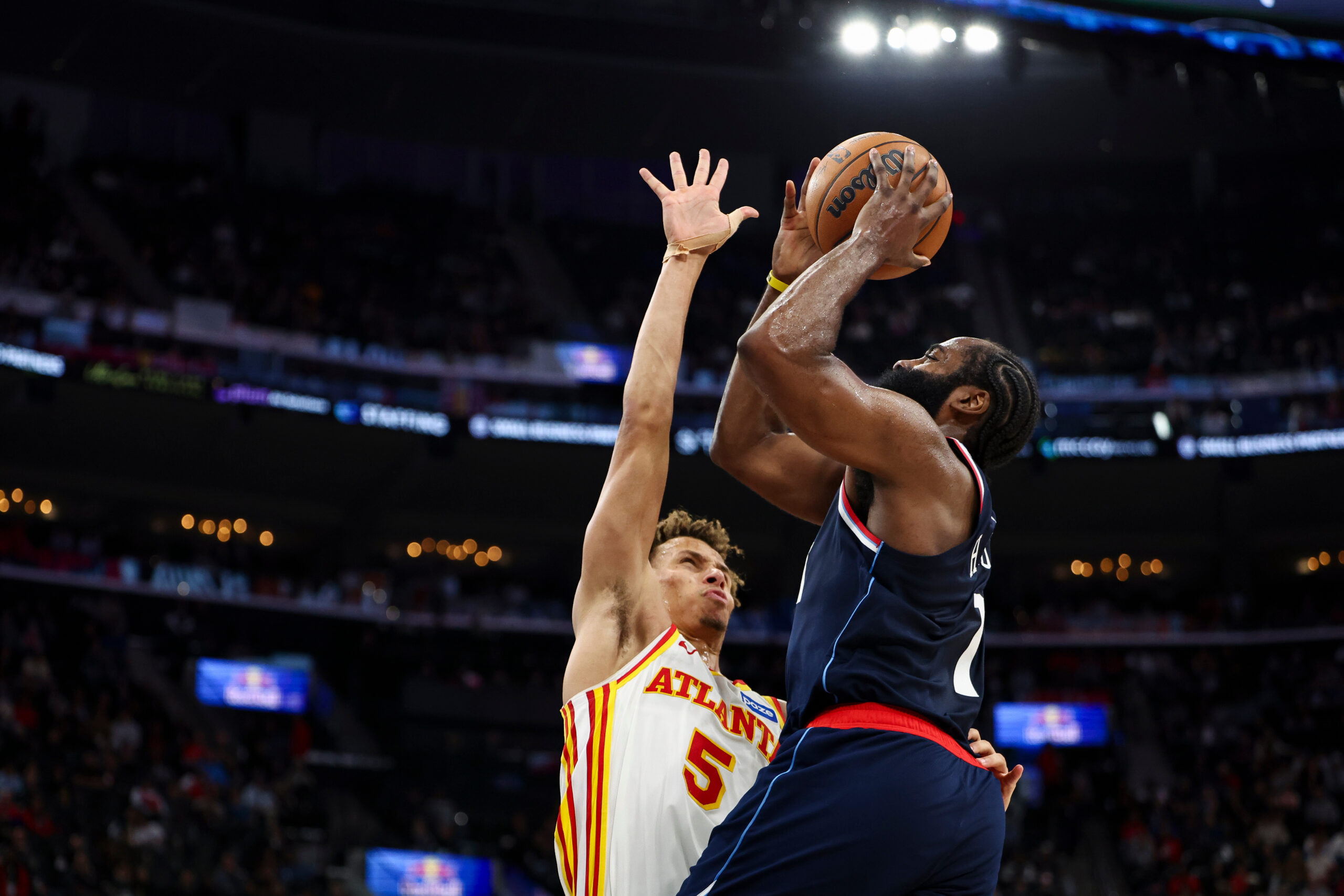 Clippers guard James Harden, right, drives Atlanta Hawks guard Dyson...