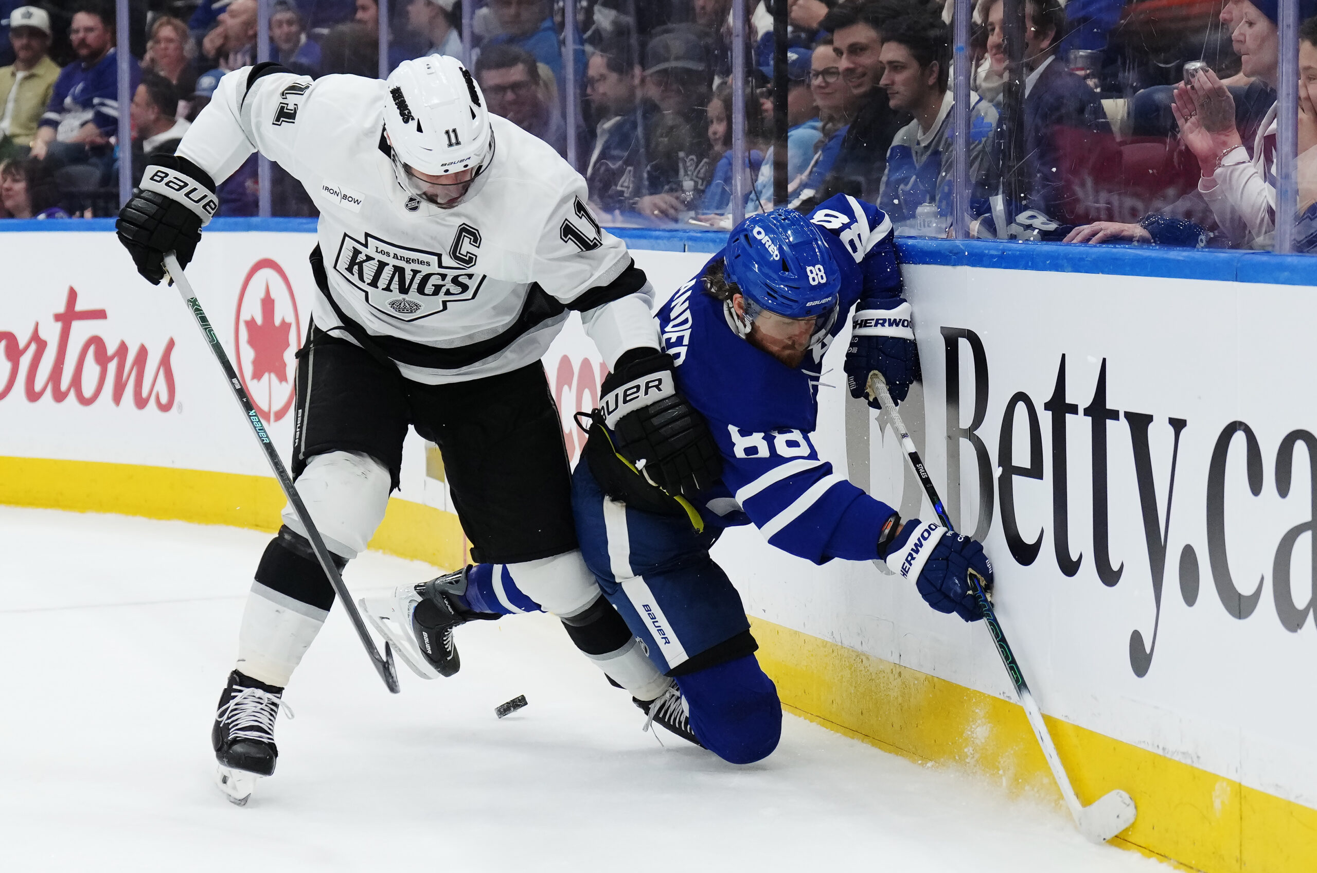 Kings captain Anze Kopitar, left, checks the Toronto Maple Leafs’...