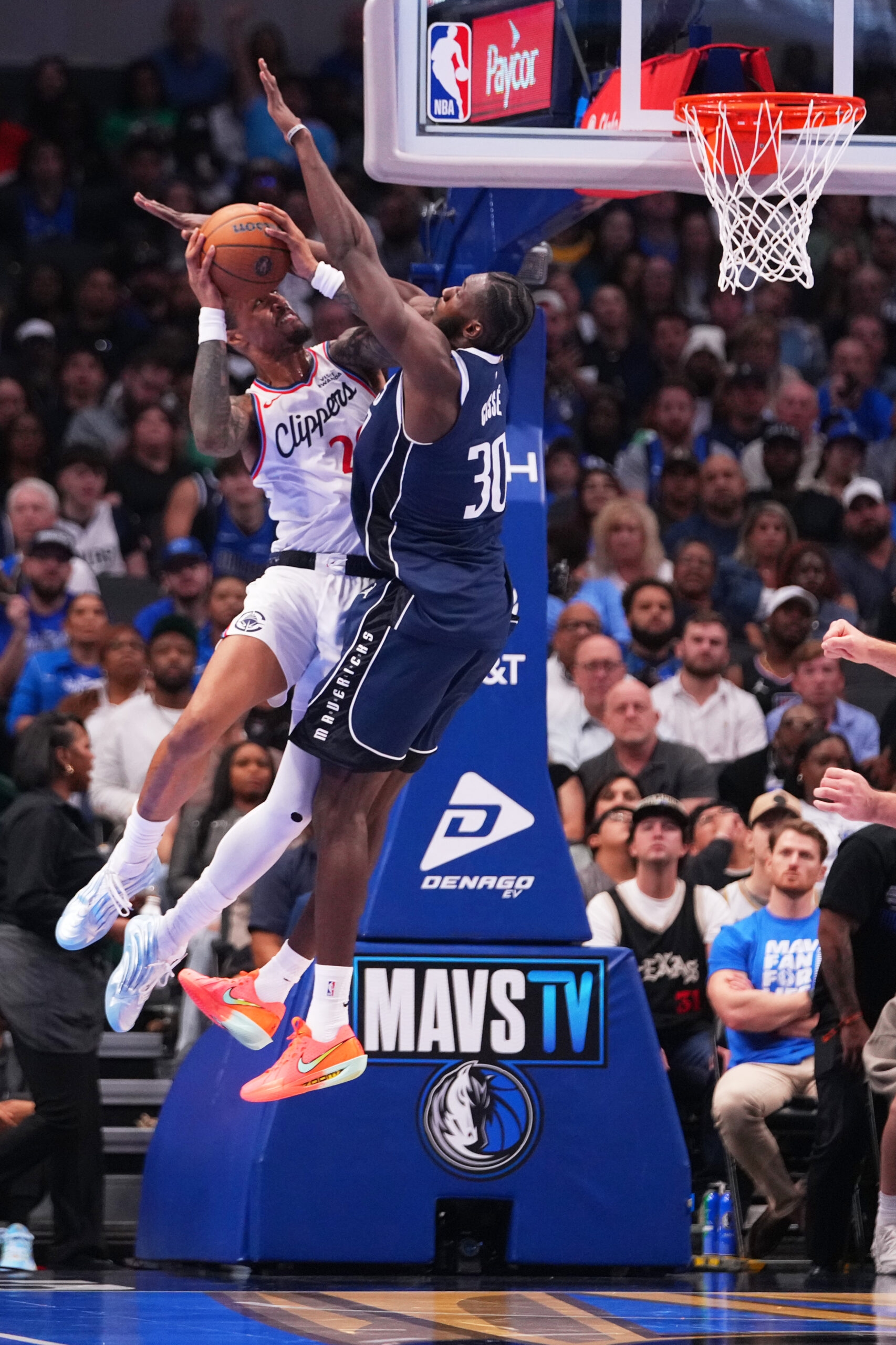 Clippers forward John Collins, left, goes up for a basket...