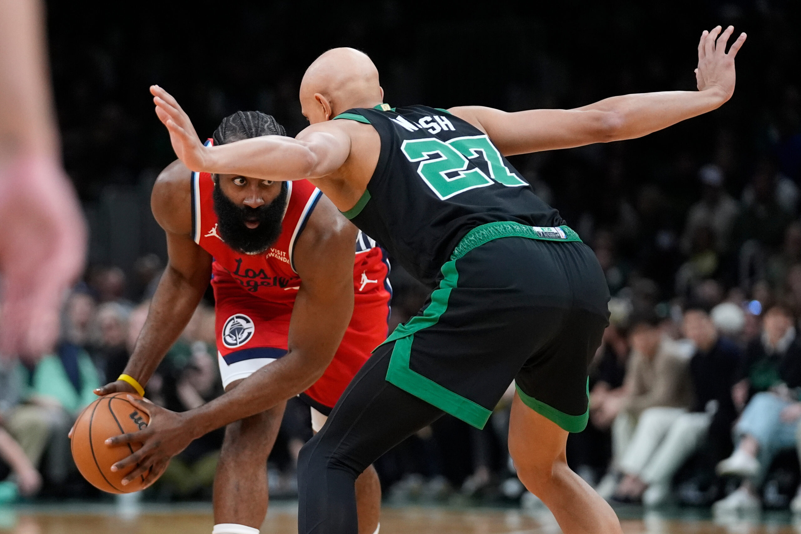 Clippers guard James Harden, left, looks to drive Boston Celtics...