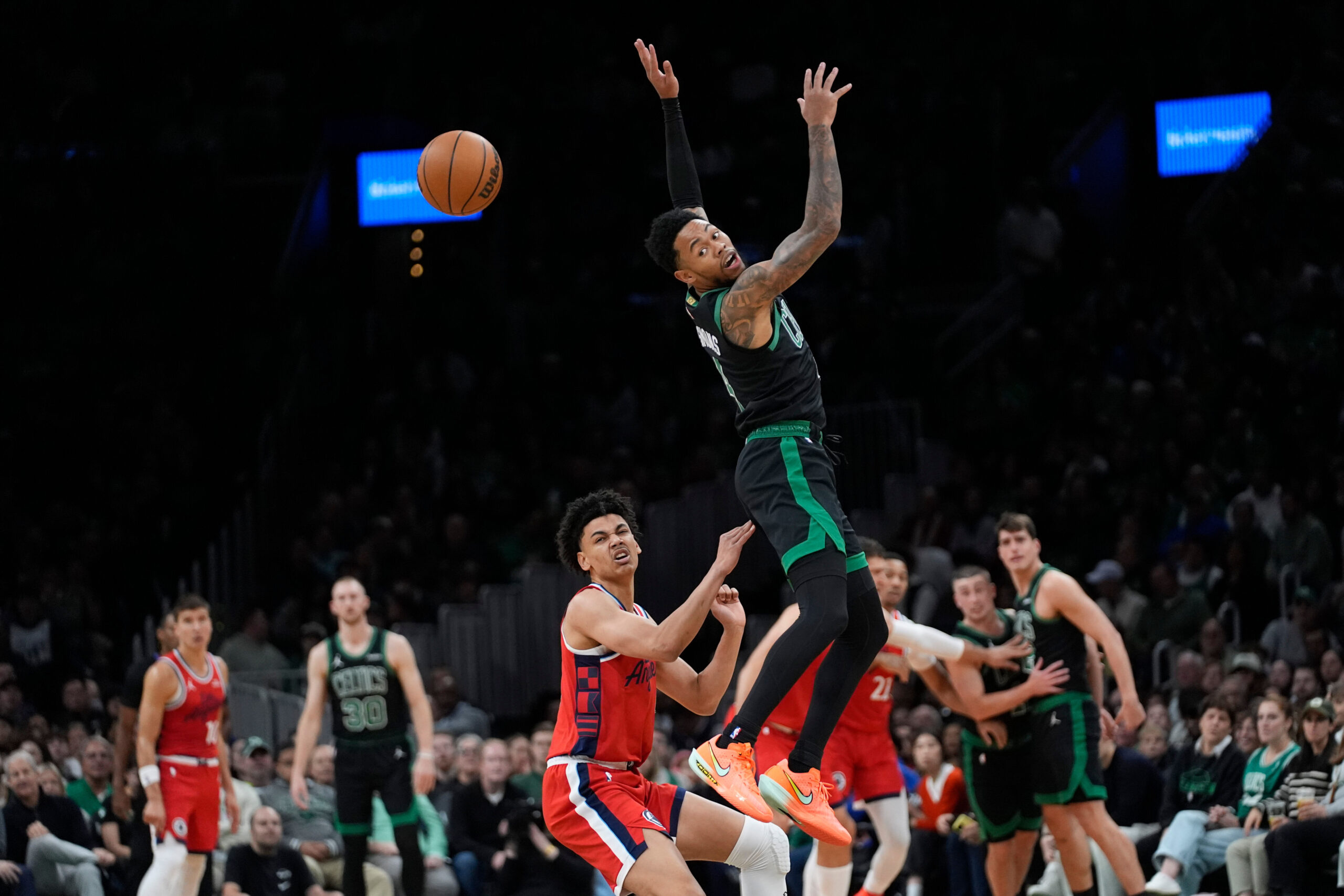 Boston Celtics Anfernee Simons, top, misses a pass while being...