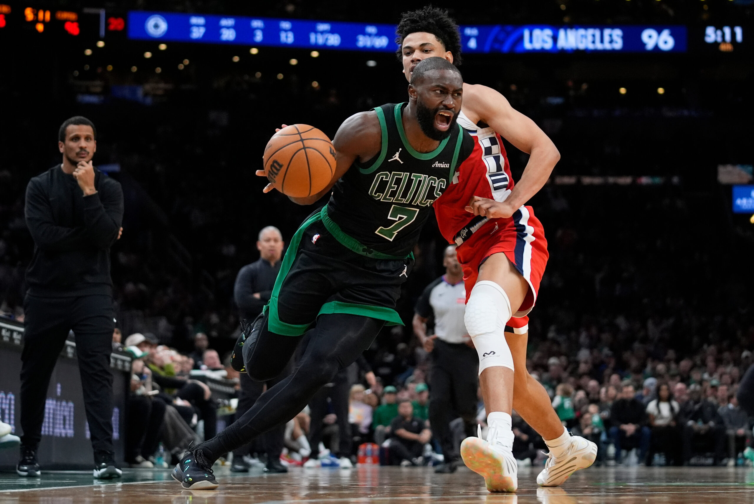 Boston Celtics guard Jaylen Brown, front, drives by Clippers guard...