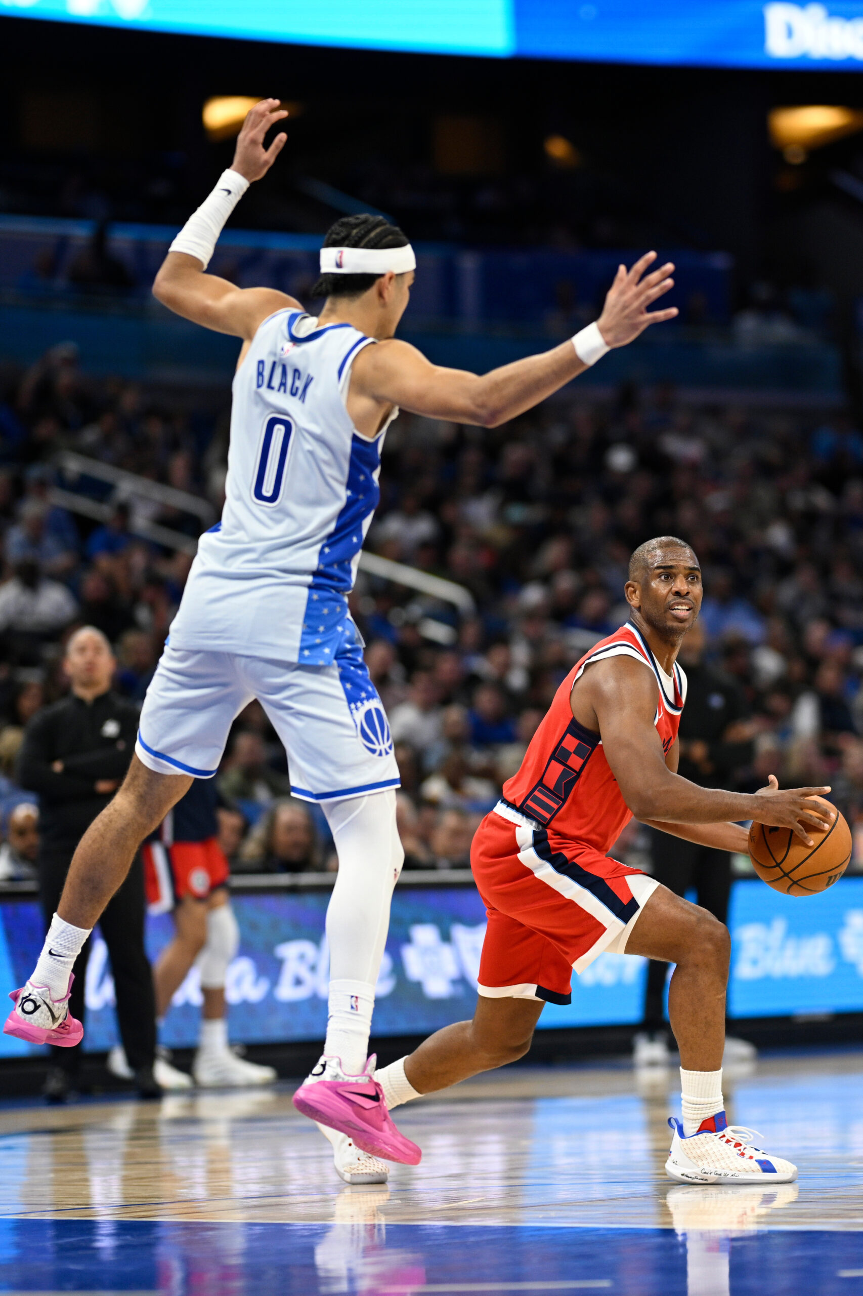 Clippers guard Chris Paul, right, looks to pass the ball...