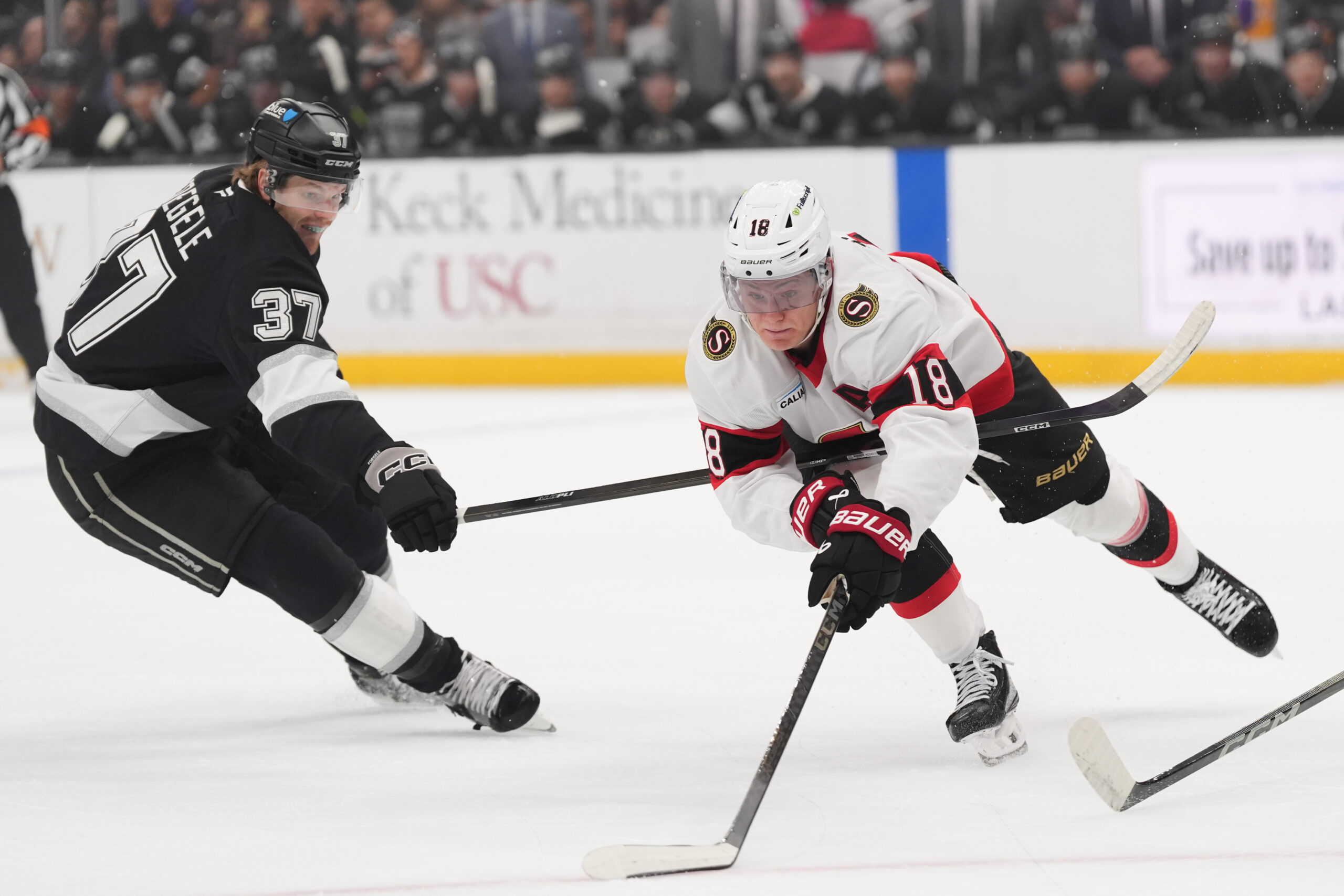 Ottawa Senators center Tim Stützle, right, moves the puck as...