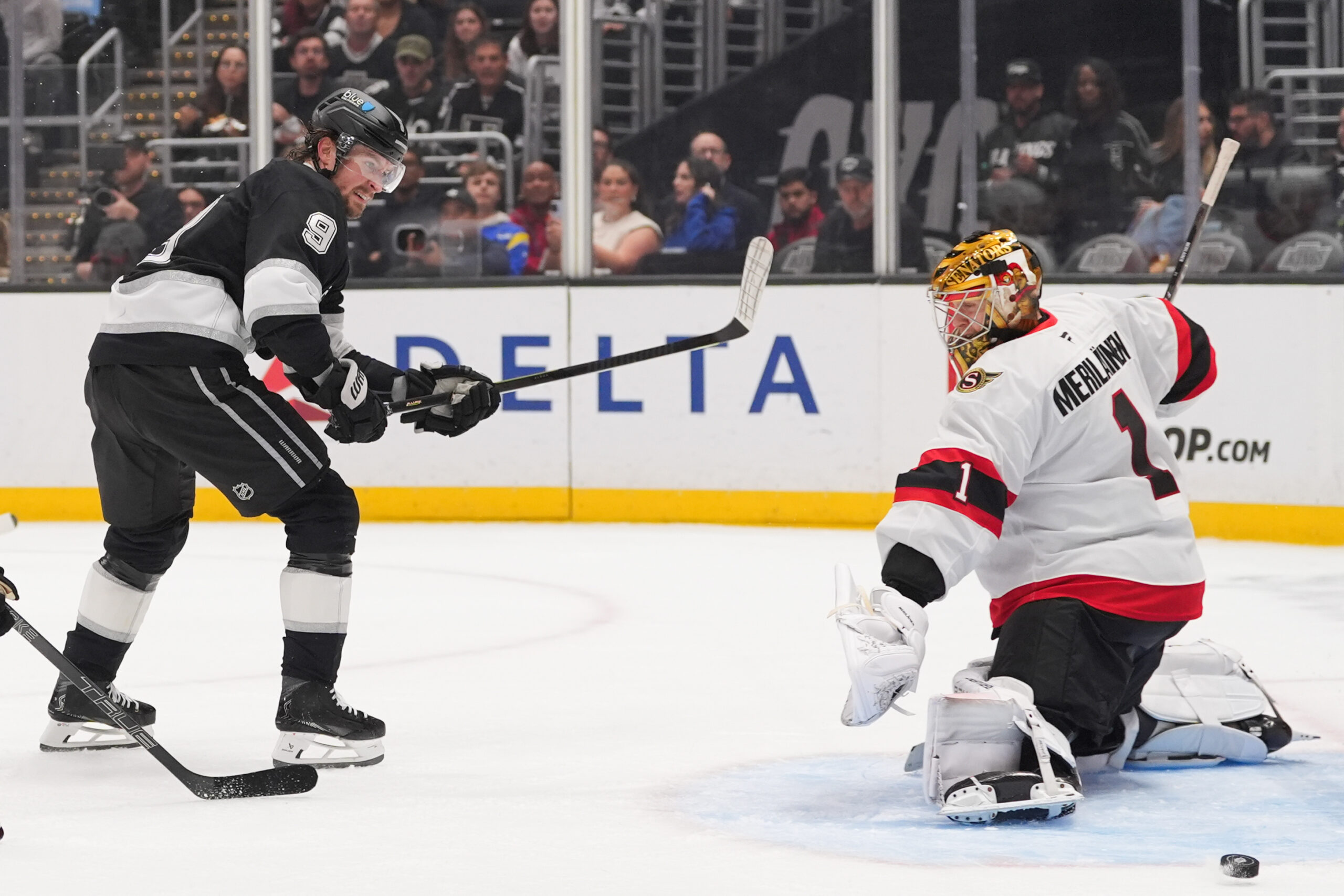 Ottawa Senators goaltender Leevi Merilainen, right, makes a save against...
