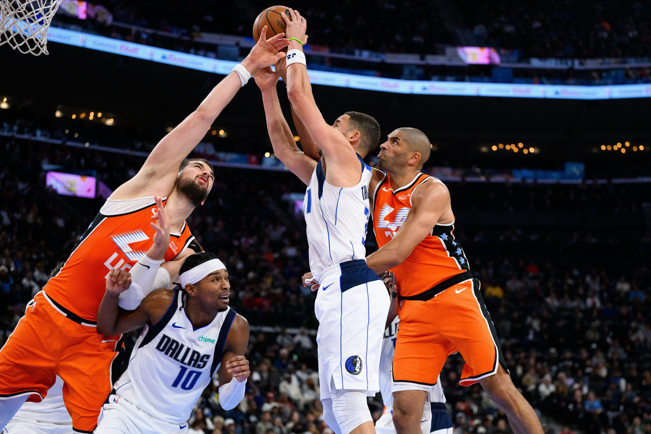 Dallas Mavericks guard Klay Thompson, center, guard Brandon Williams (10),...