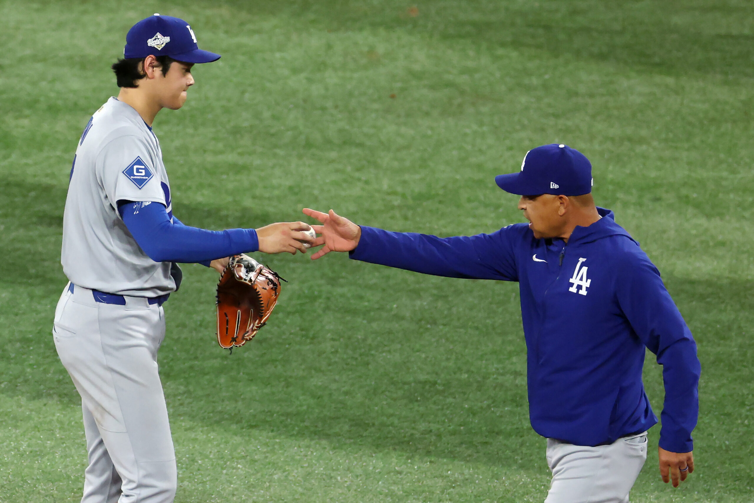 Dodgers manager Dave Roberts, right, takes the ball from starting...