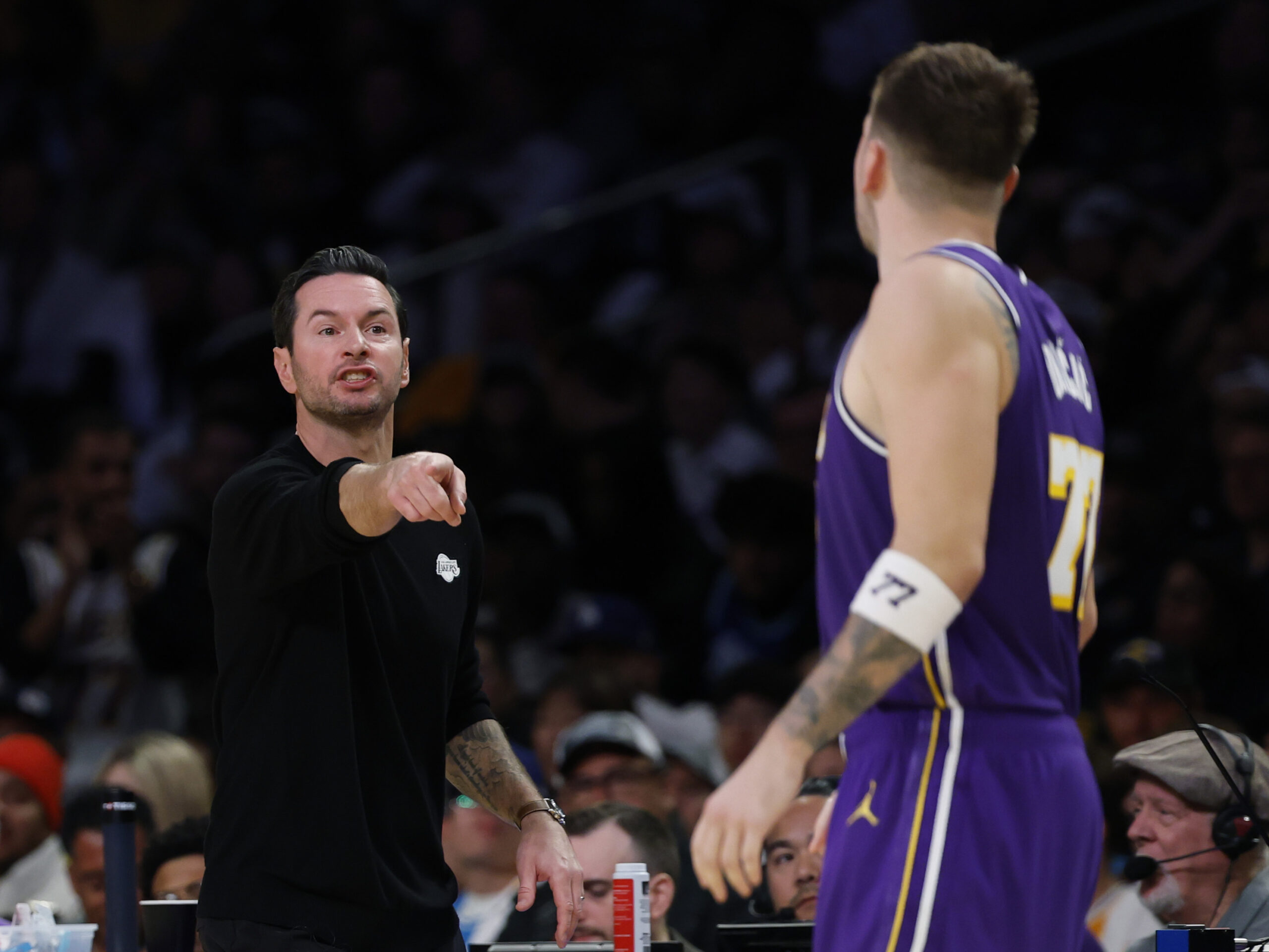 Lakers head coach JJ Redick talks to star Luka Doncic...
