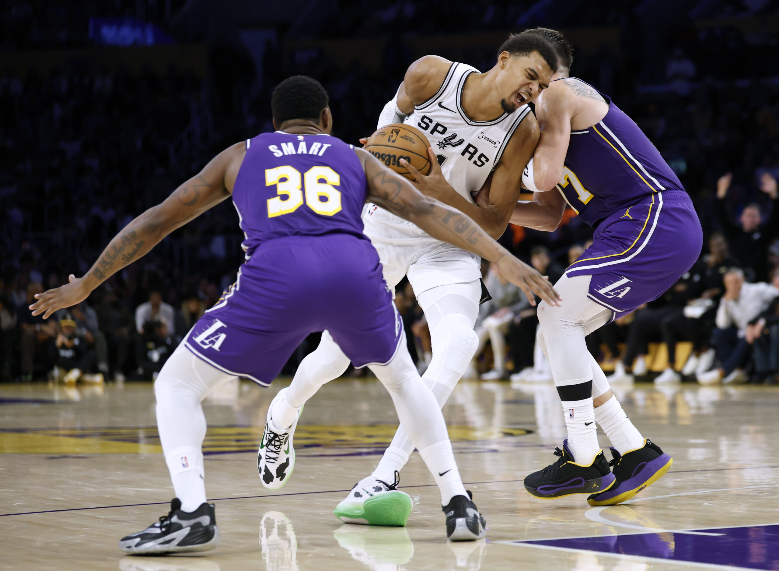 San Antonio Spurs star Victor Wembanyama, center, reacts as he...