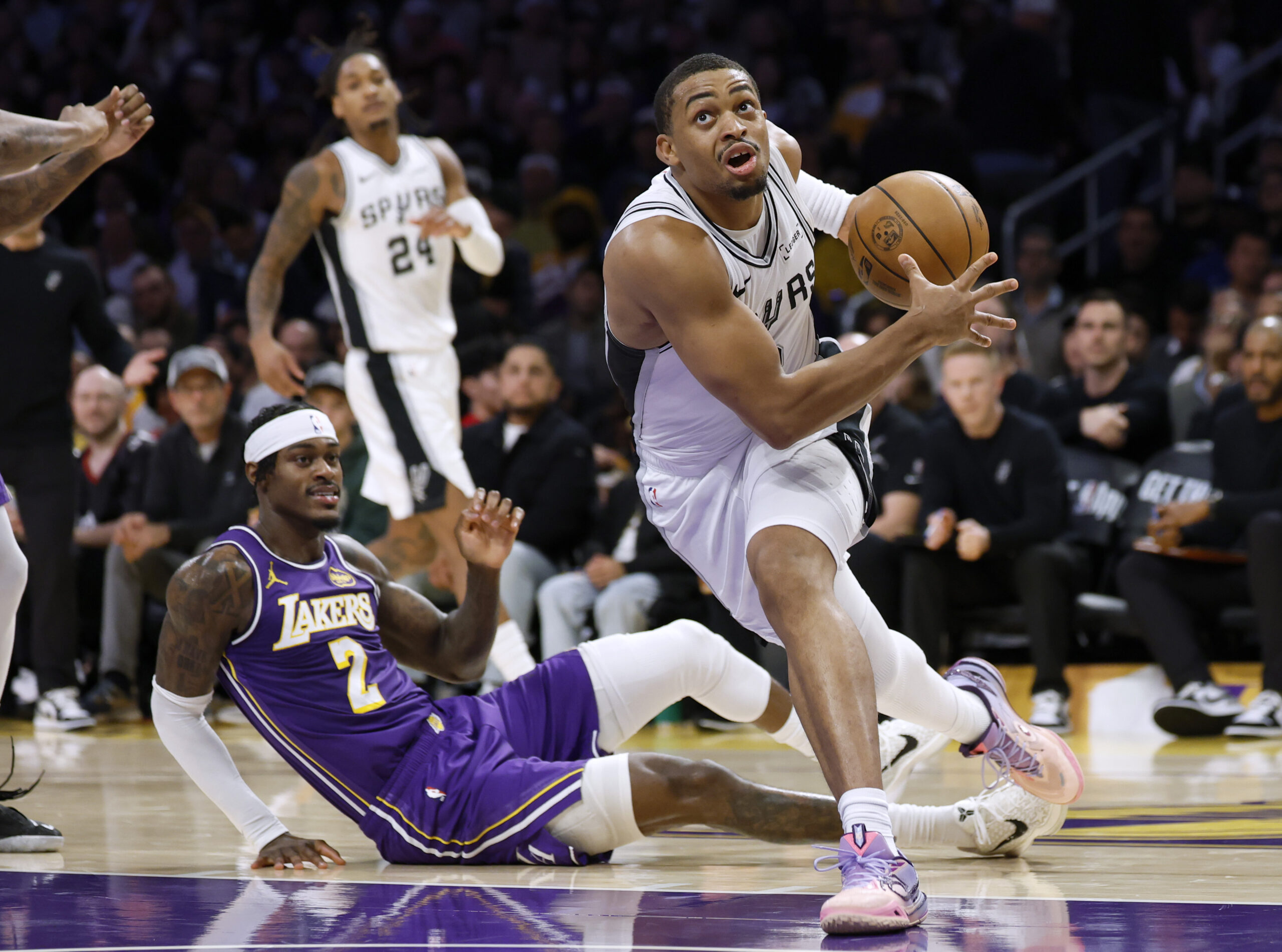 The San Antonio Spurs’ Keldon Johnson, right, drives to the...