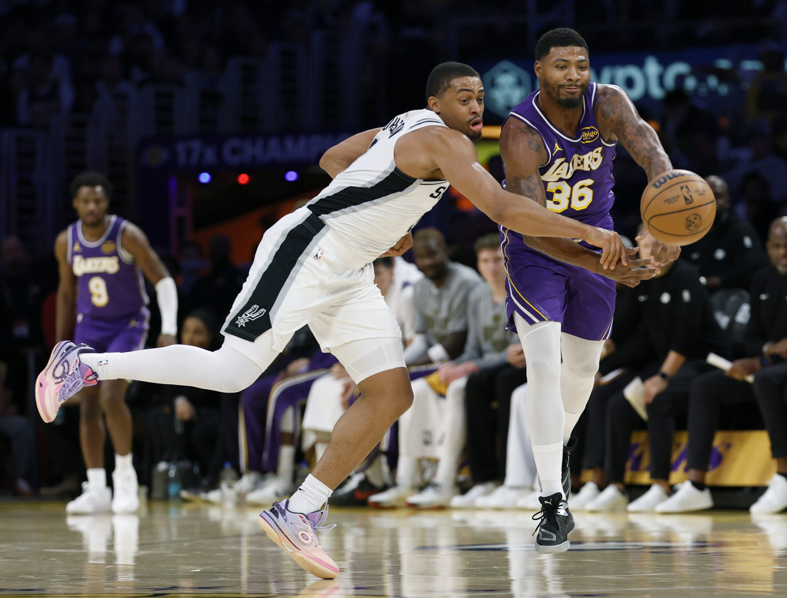 The San Antonio Spurs’ Keldon Johnson, left, steals the ball...
