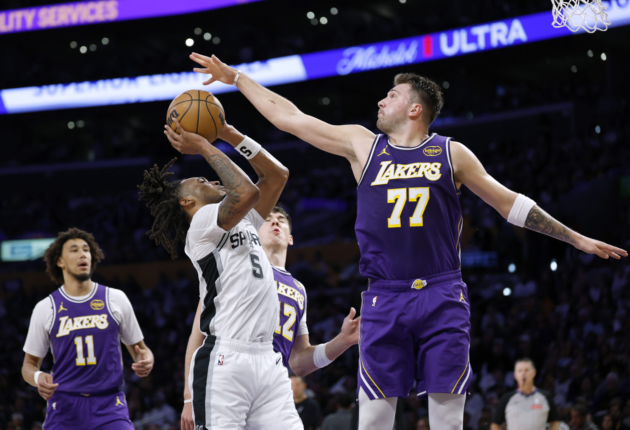 Lakers star Luka Doncic blocks the sot of the San...