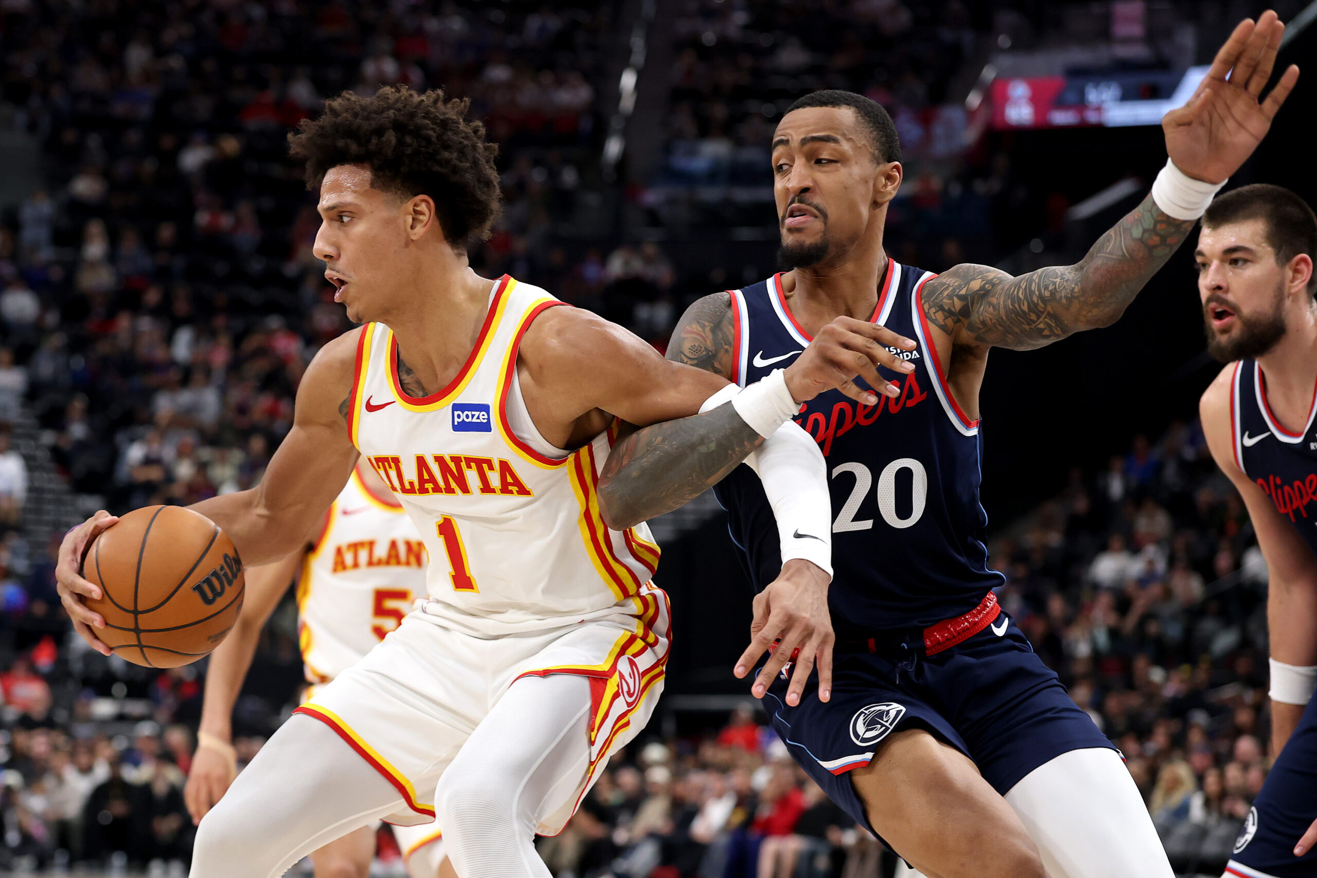 Clippers forward John Collins, right, defends against the Atlanta Hawks’...