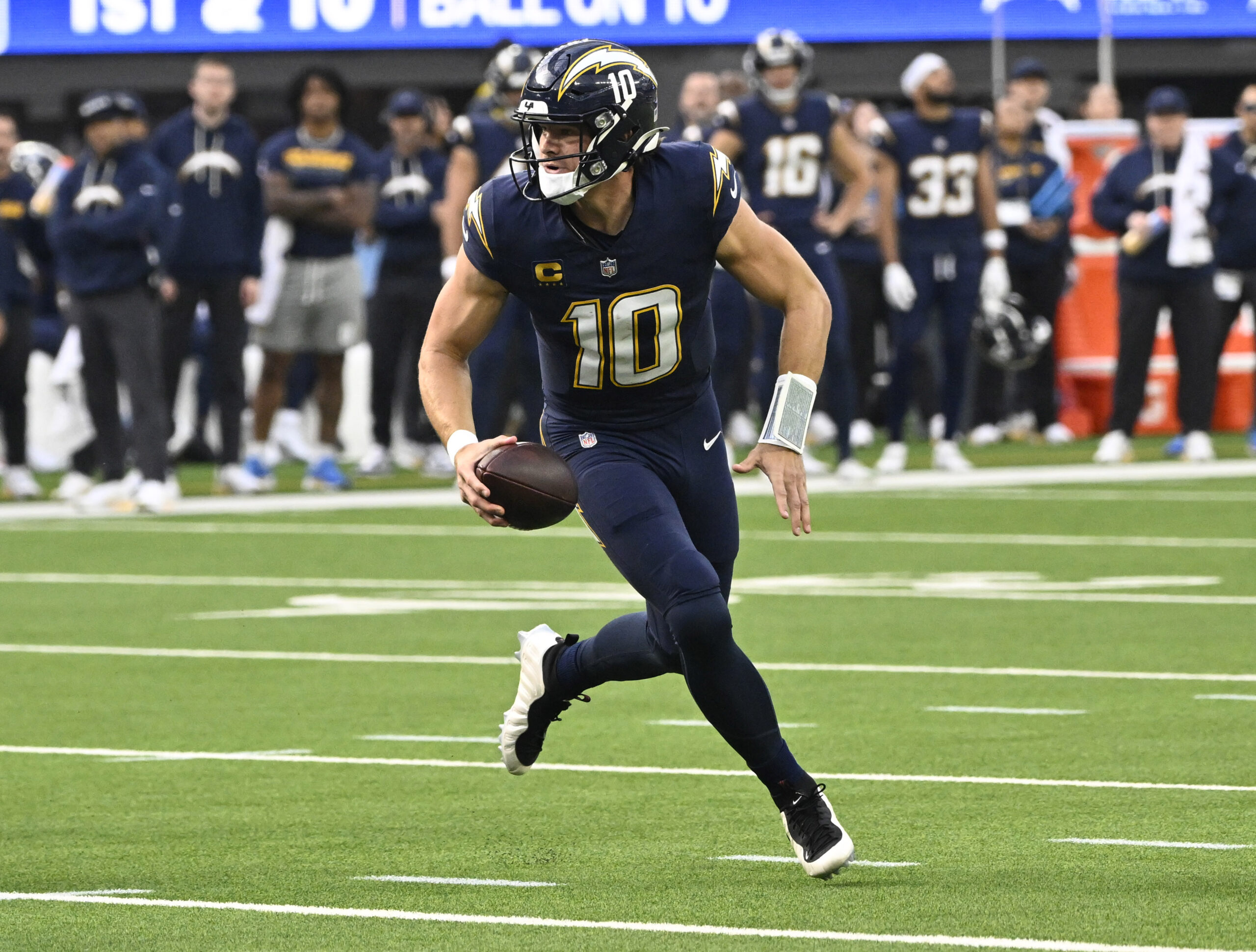 Quarterback Justin Herbert #10 of the Los Angeles Chargers scrambls...